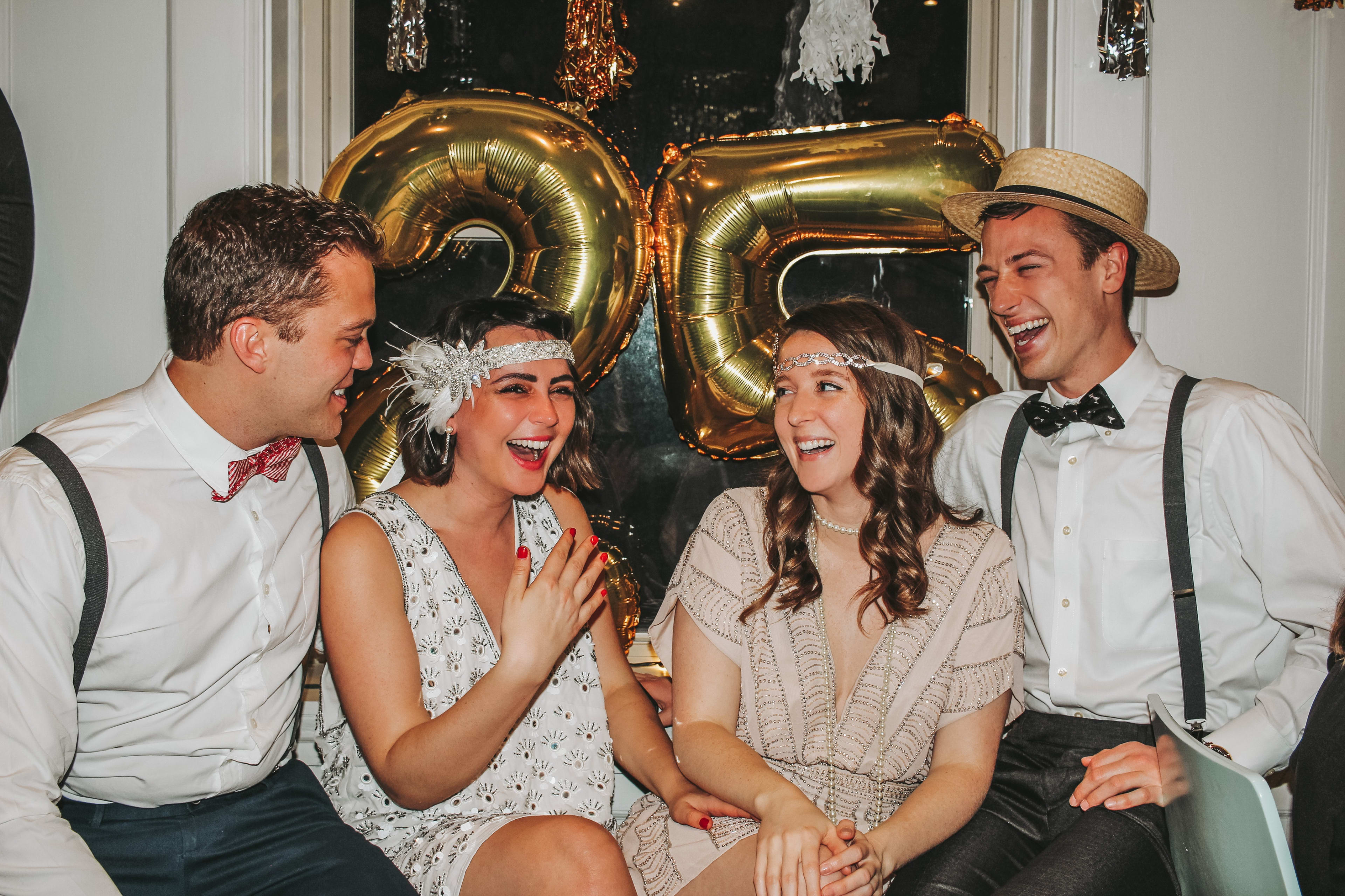 A group of people dress for a costume party sitting next to each other.