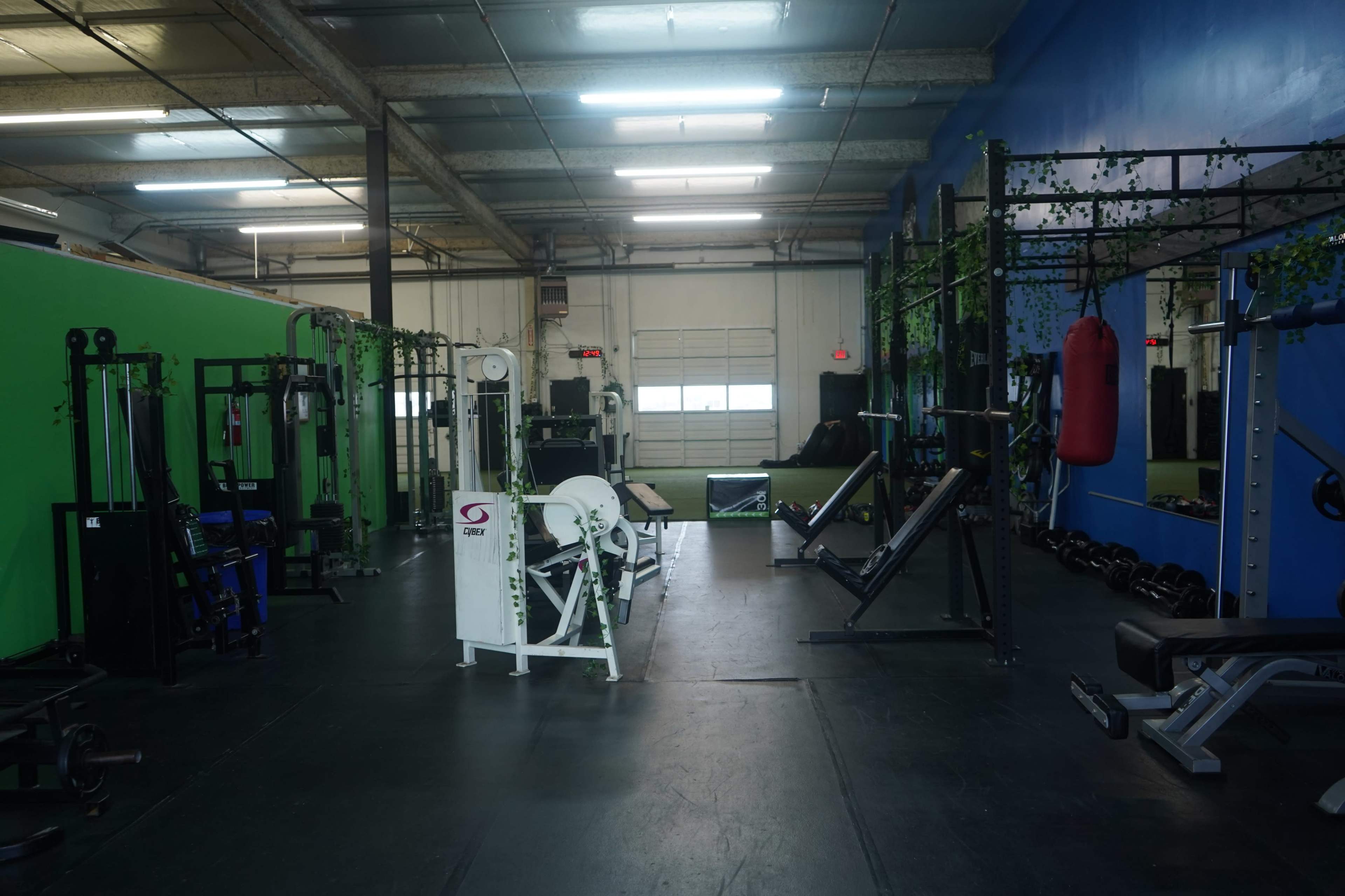 The image shows a fitness gym interior with various exercise equipment arranged throughout the space.