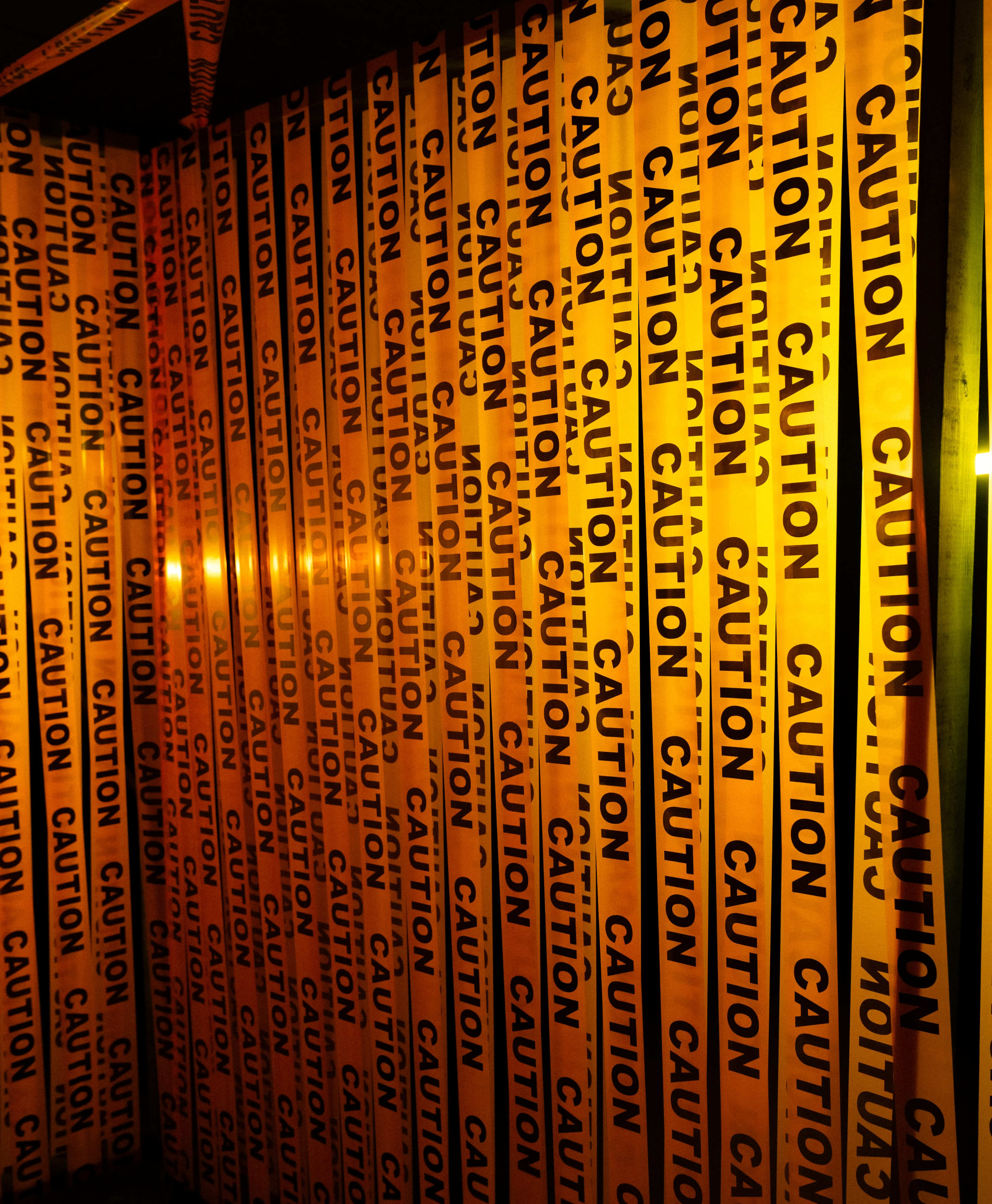 The image shows a series of yellow caution tape strips with the word "CAUTION" printed repetitively in black.