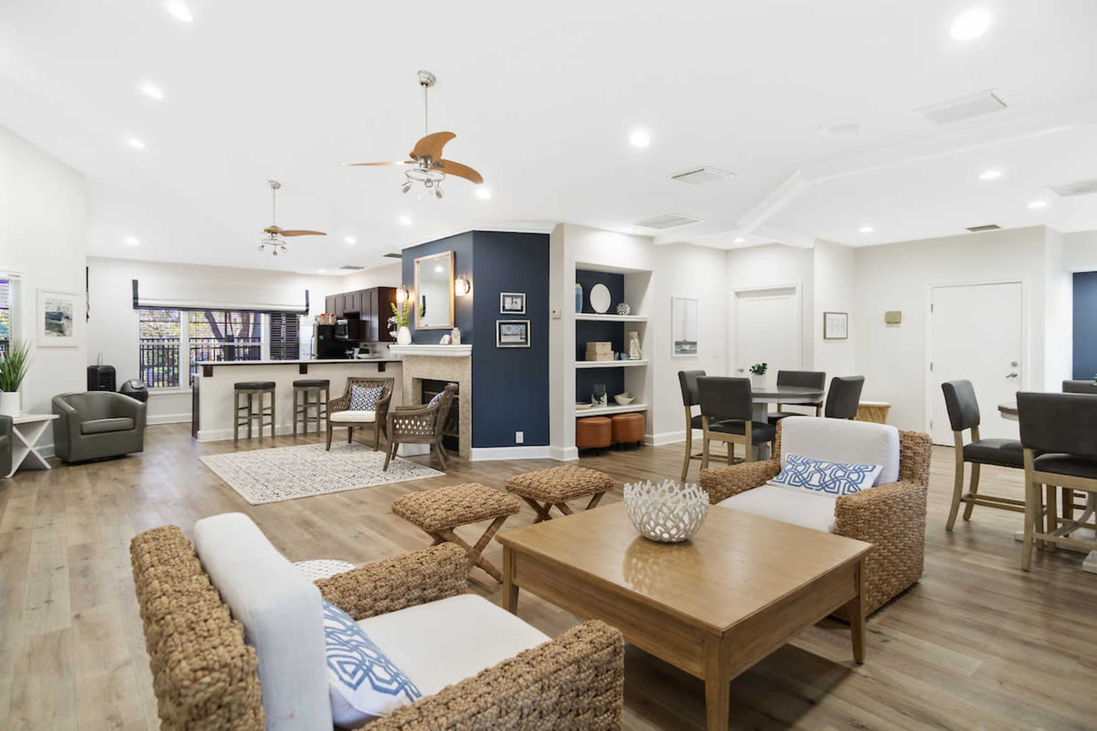 A bright and modern lounge area with comfortable seating, wooden flooring, a bar-like counter, and decorative elements.