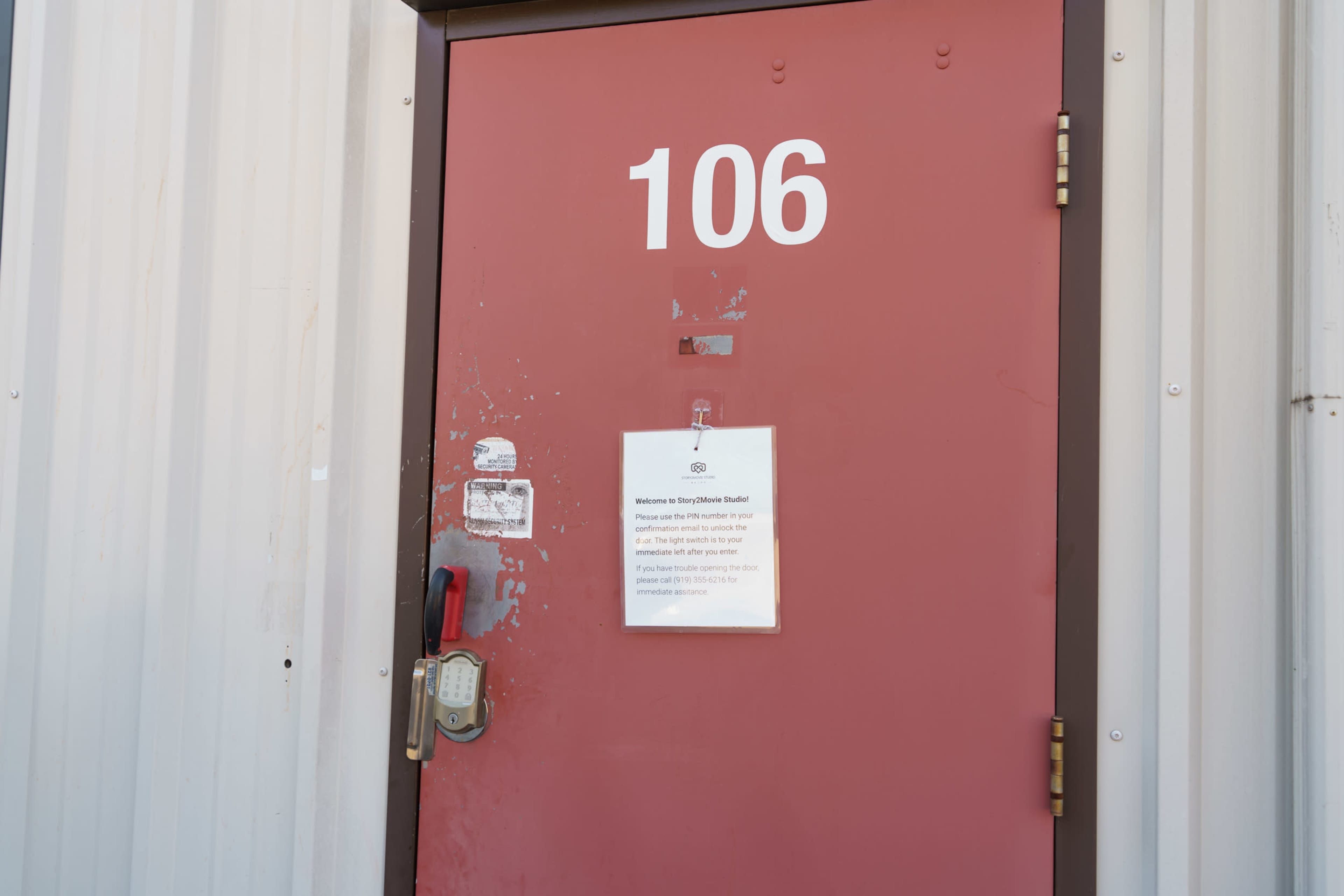 A red door numbered 106 features a notice attached to it with instructions.