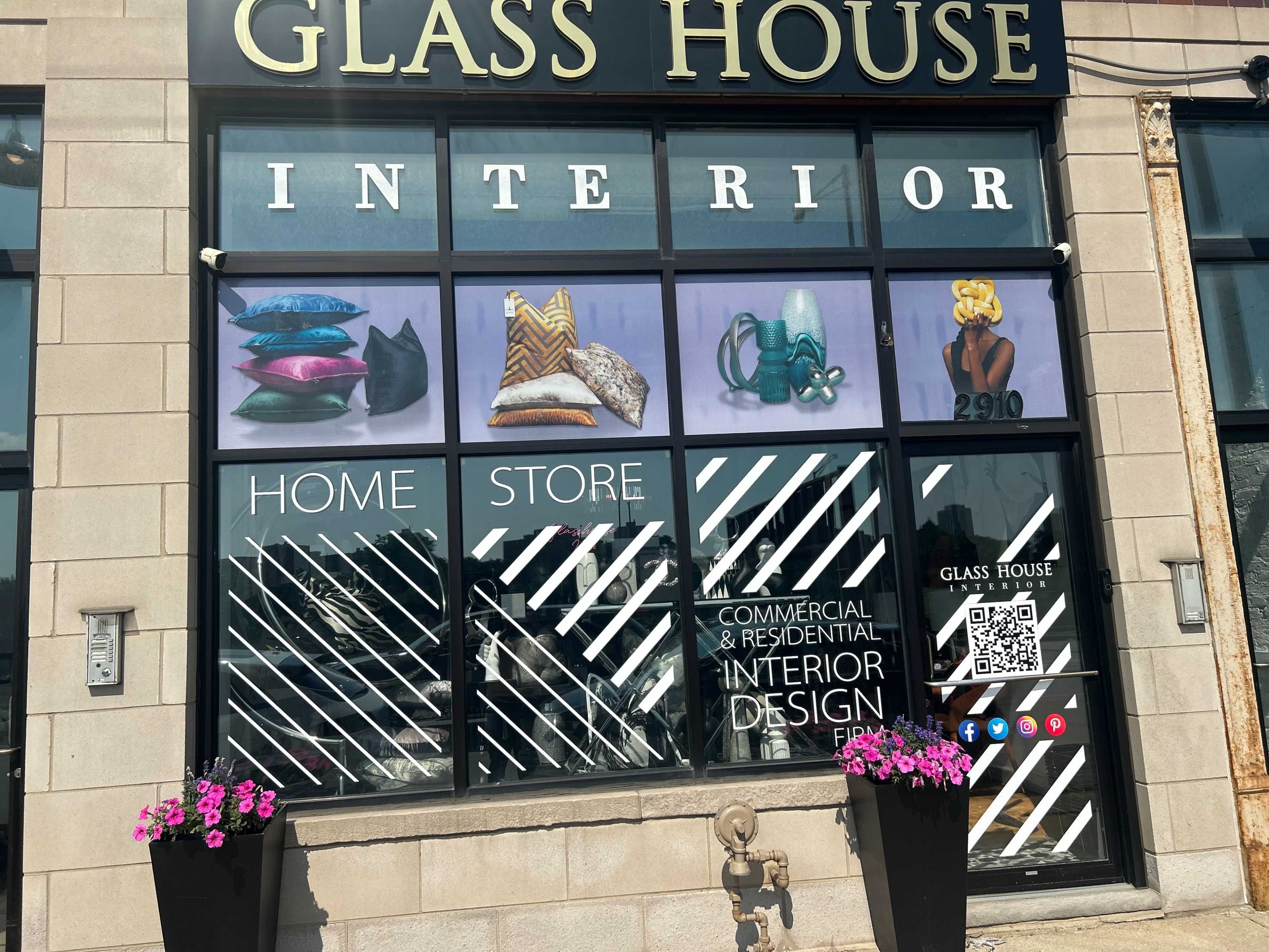 The storefront of "Glass House Interior" features large windows displaying decorative pillows and accessories, with promotional text for home and commercial interior design.