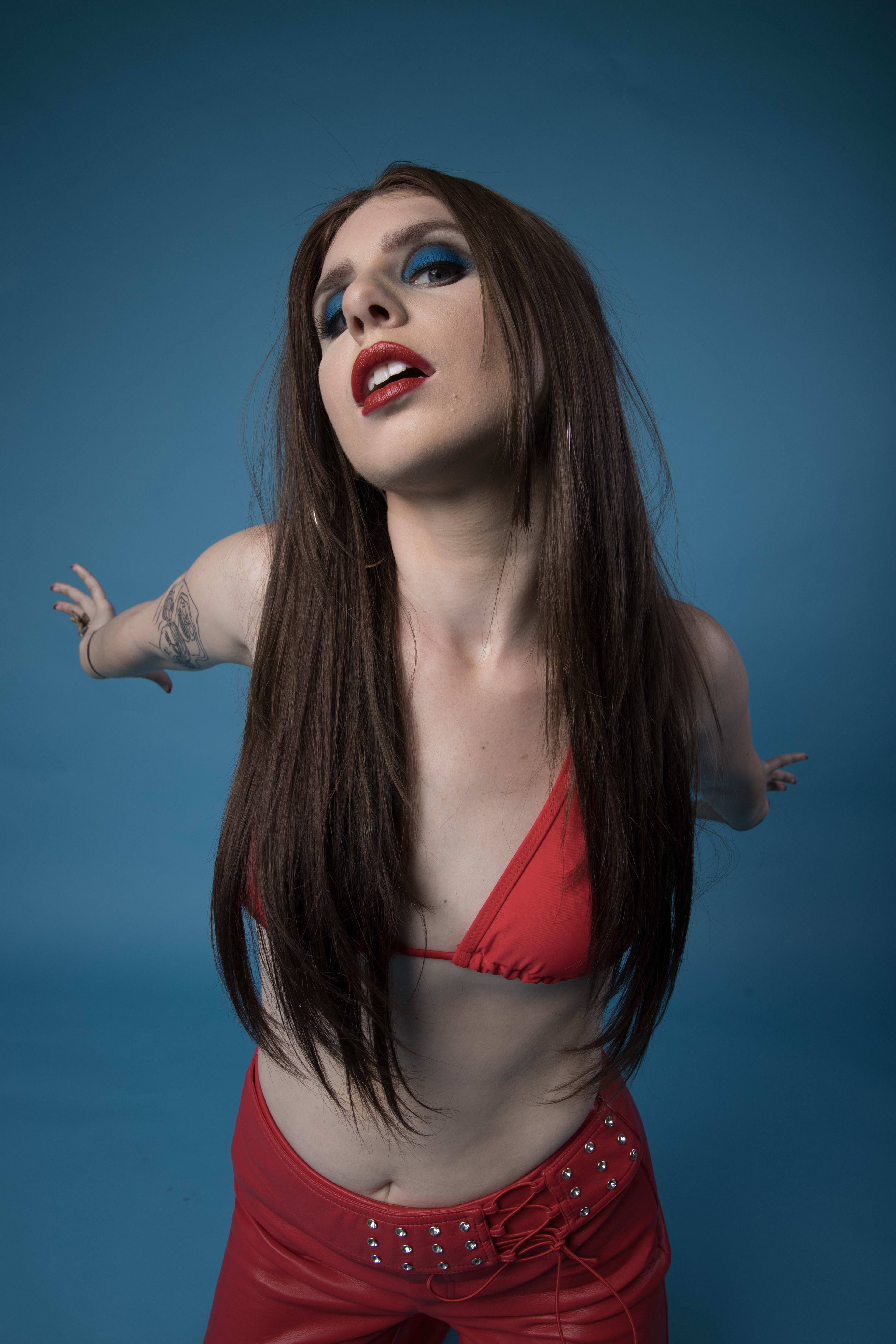 A fashion photoshoot featuring a woman in a red bikini top with matching pants.