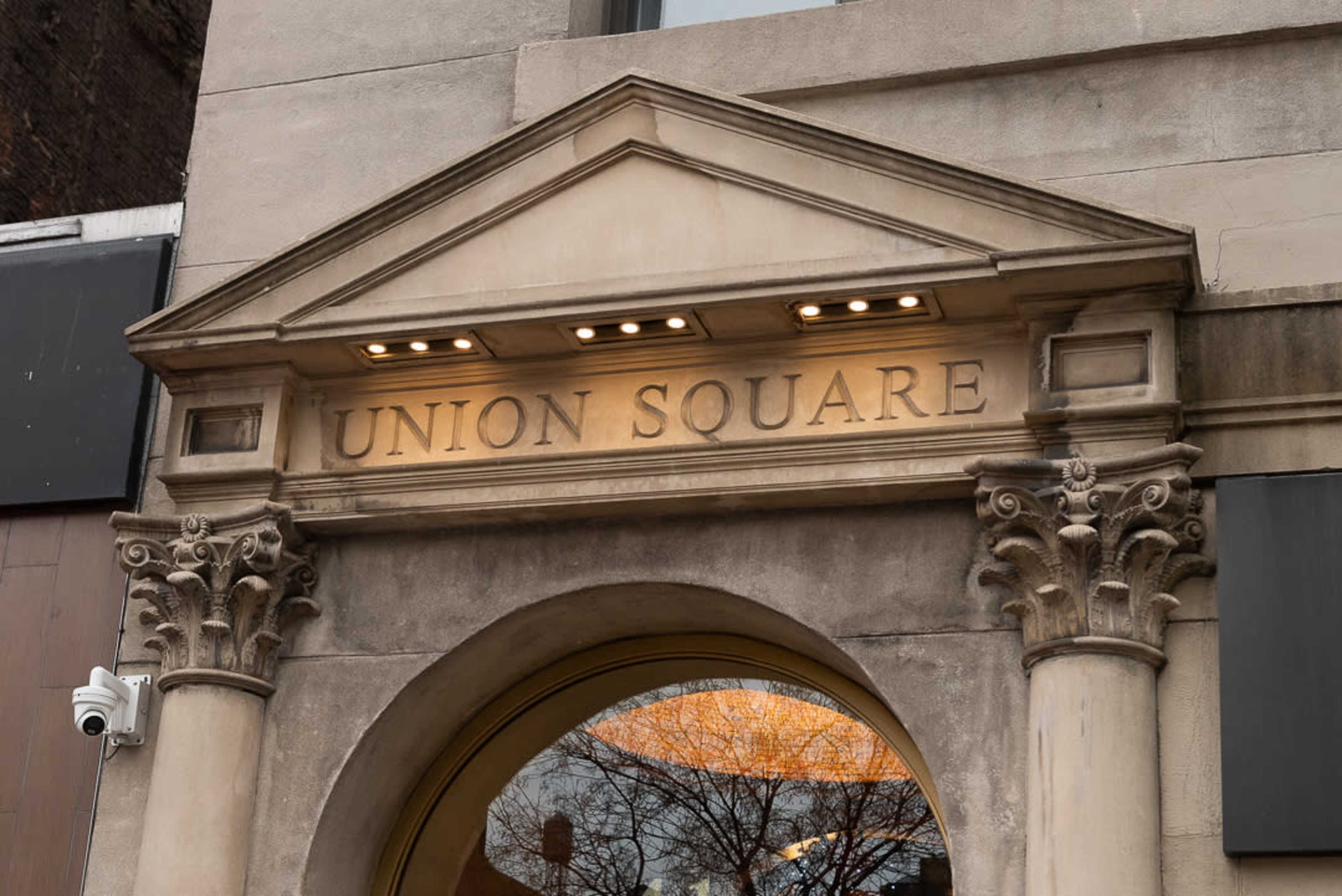 A building entrance with a decorative archway inscribed with "UNION SQUARE" above it.