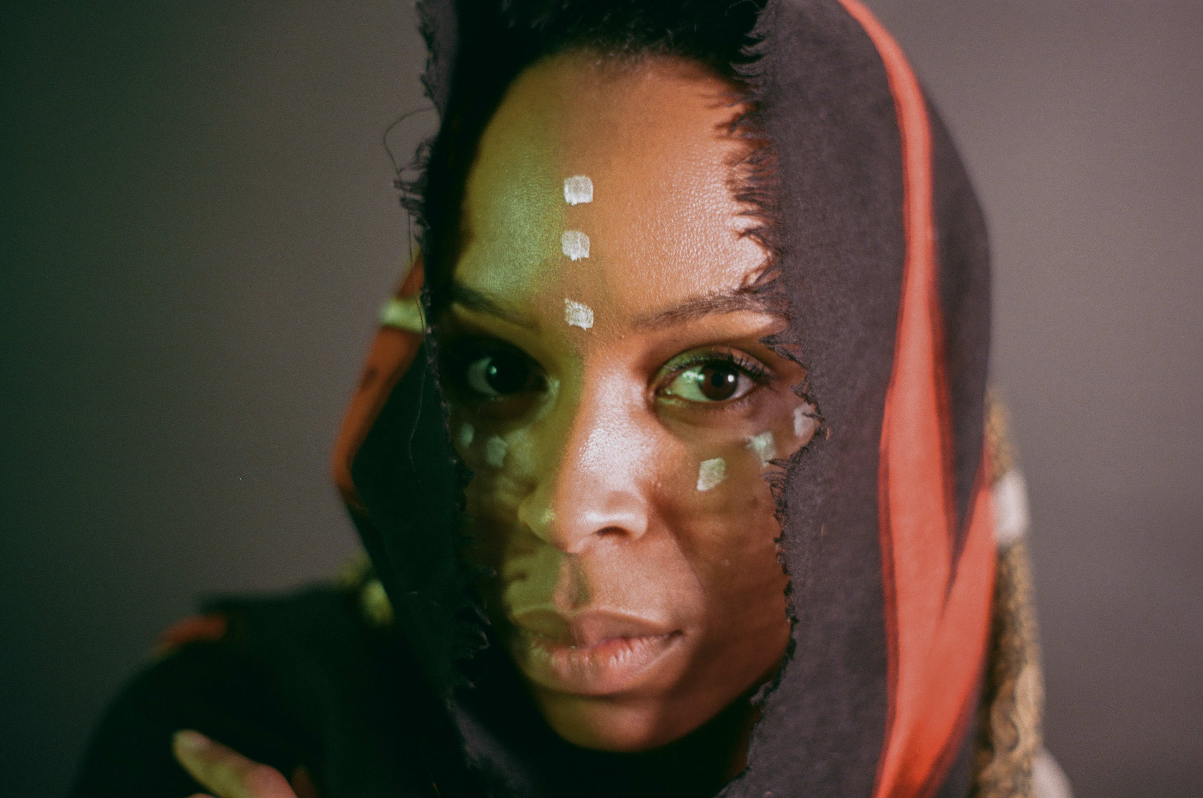 A portrait photoshoot featuring a woman with a black head scarf.