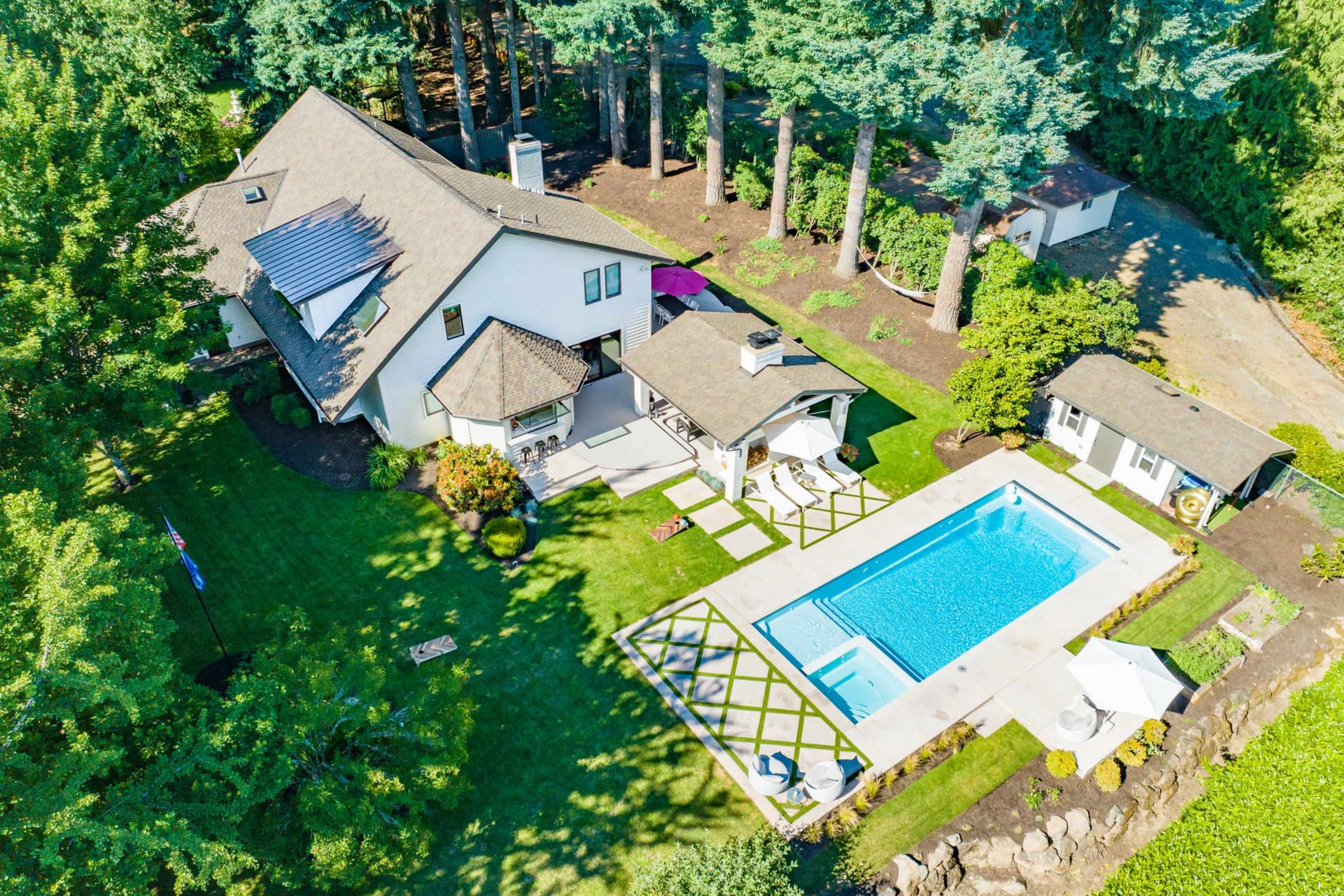 The image shows a house with a swimming pool in the backyard, surrounded by trees and landscaped green areas.