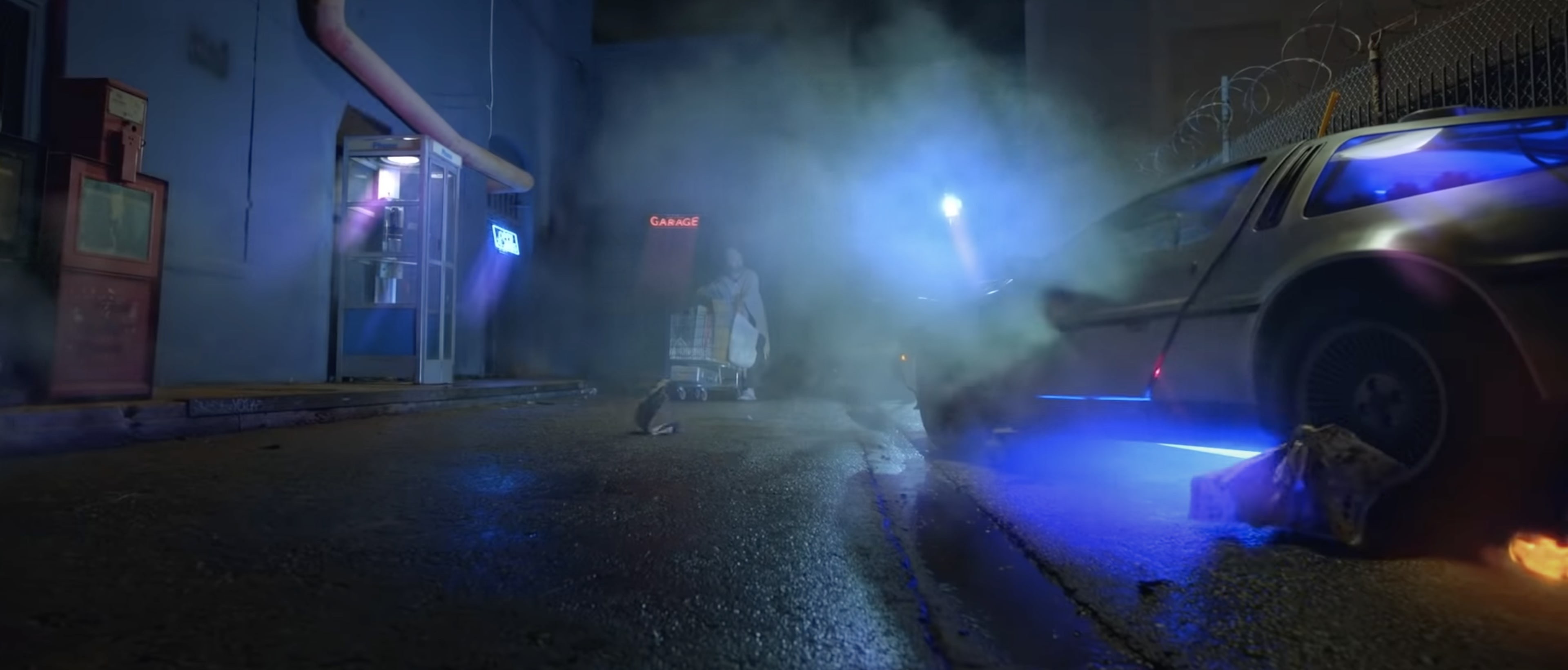 A vintage car emits blue neon lights in a misty alley, with a figure pushing a cart nearby.