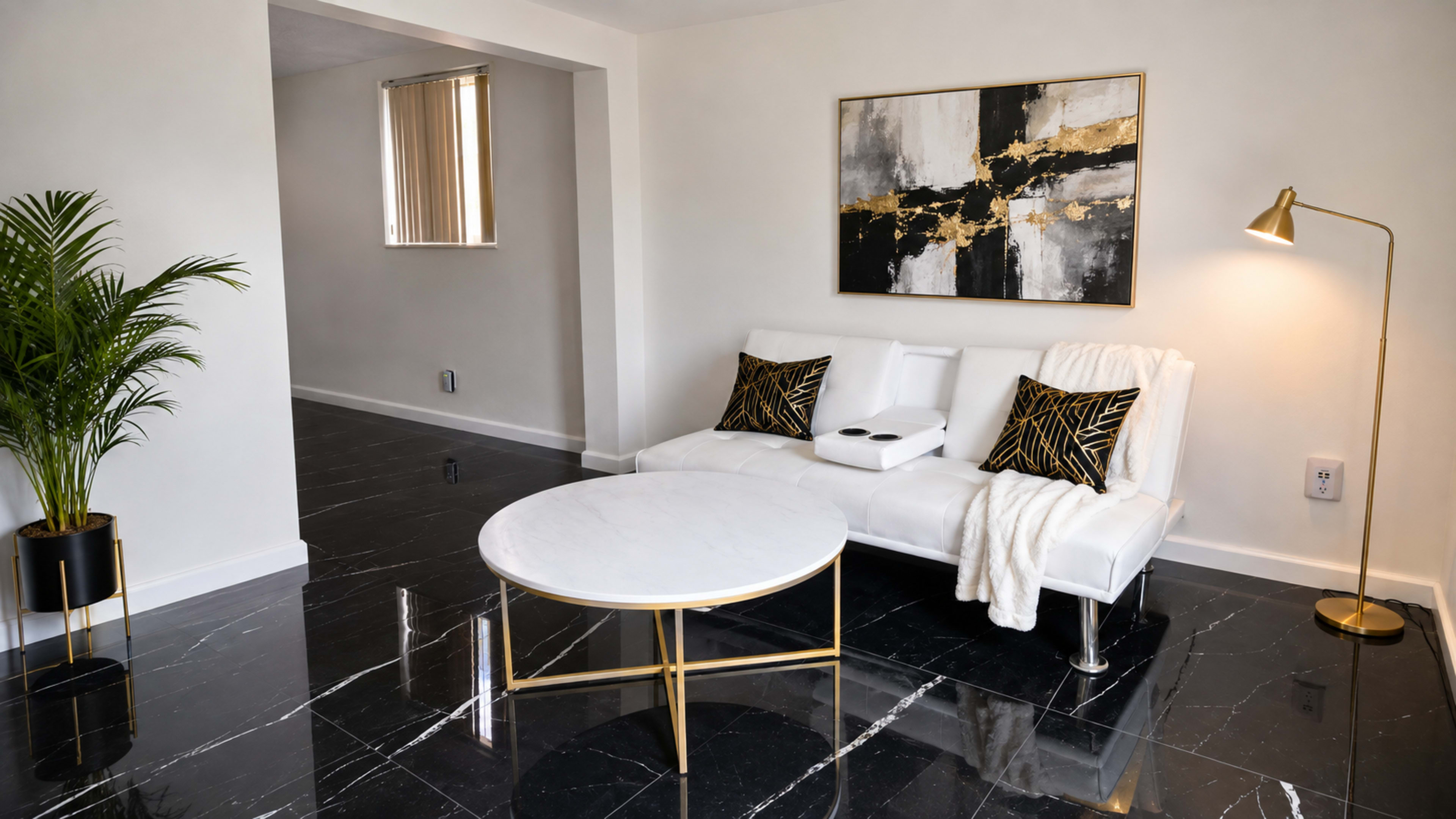 The image shows a modern living room with a white sofa, marble coffee table, gold-accented decor, and glossy black floor tiles.