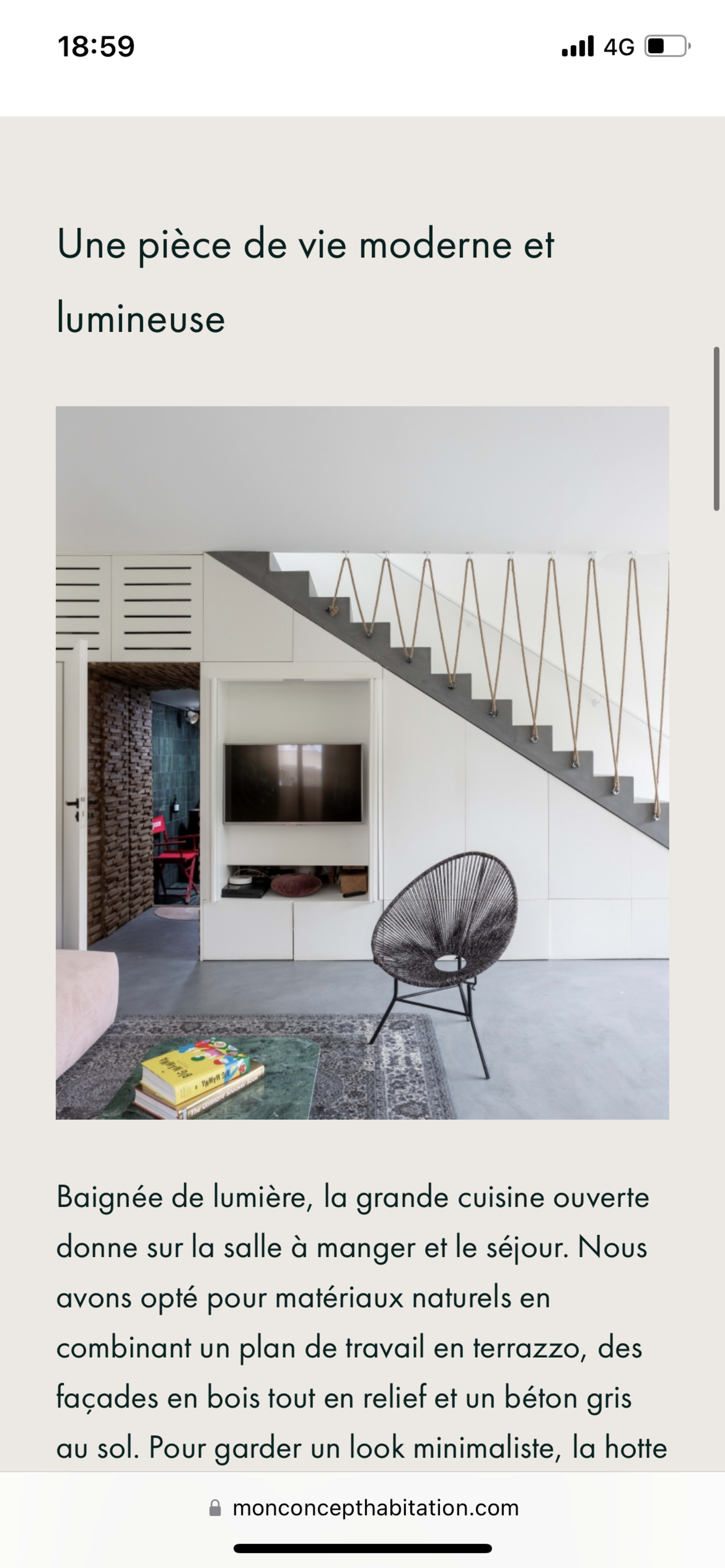 A modern living space with an open kitchen, a seating area, and a staircase featuring a minimalist design.