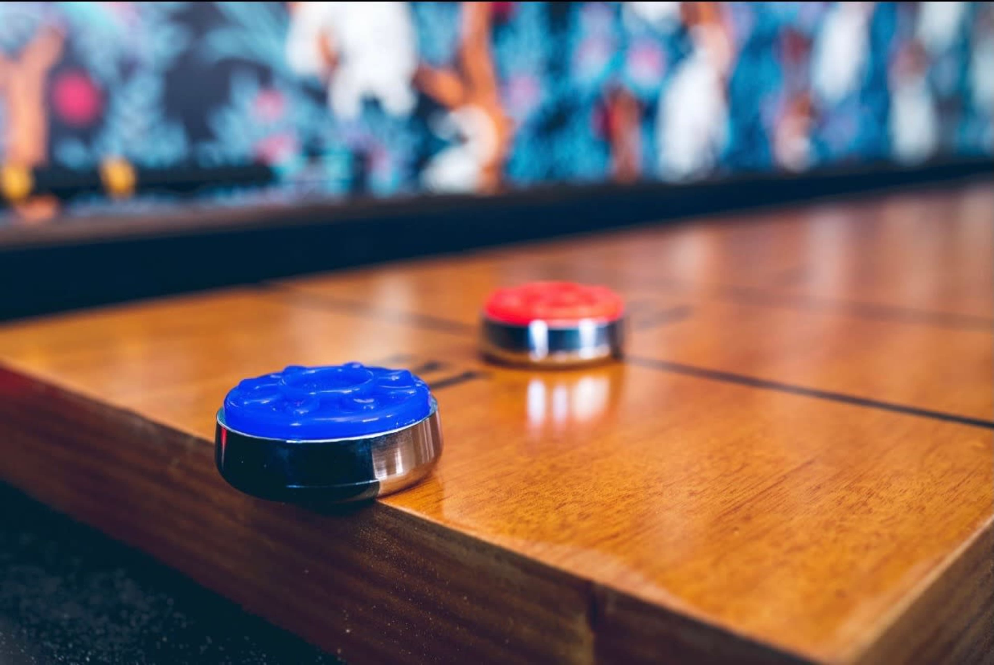 A blue and red disc are placed on a wooden board.