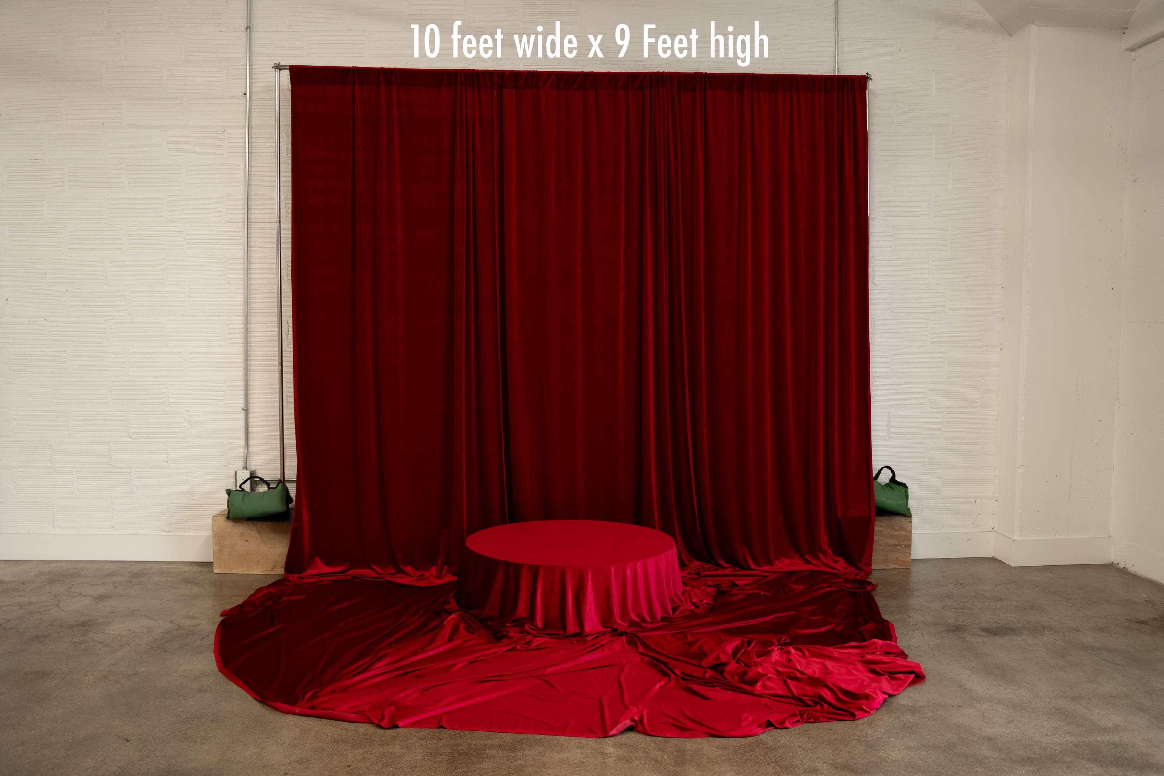 The image features a stage setup with a large red backdrop and circular platform, designed for presentations or performances.