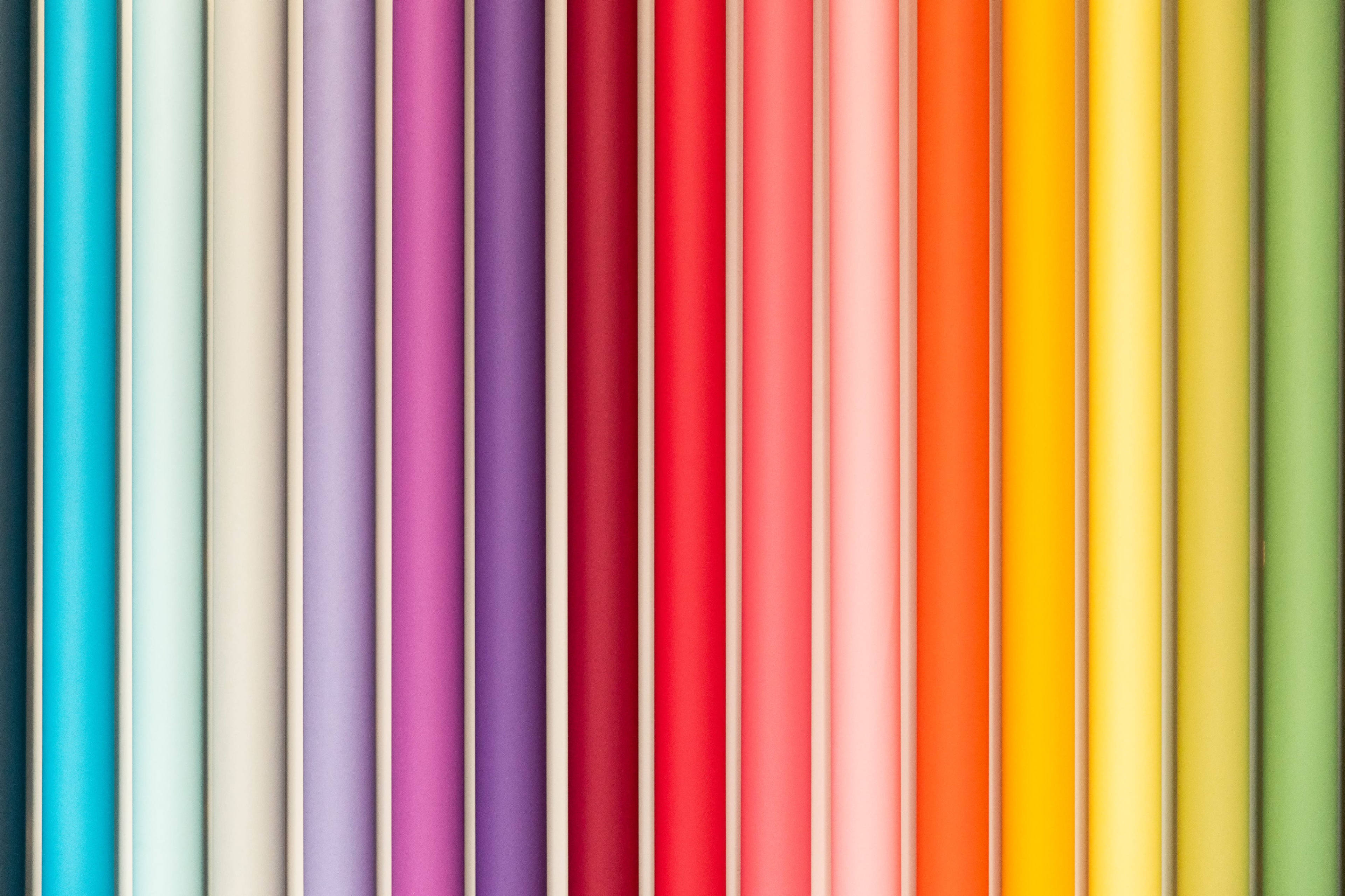 A series of rolled paper in various colors arranged in a vertical pattern.