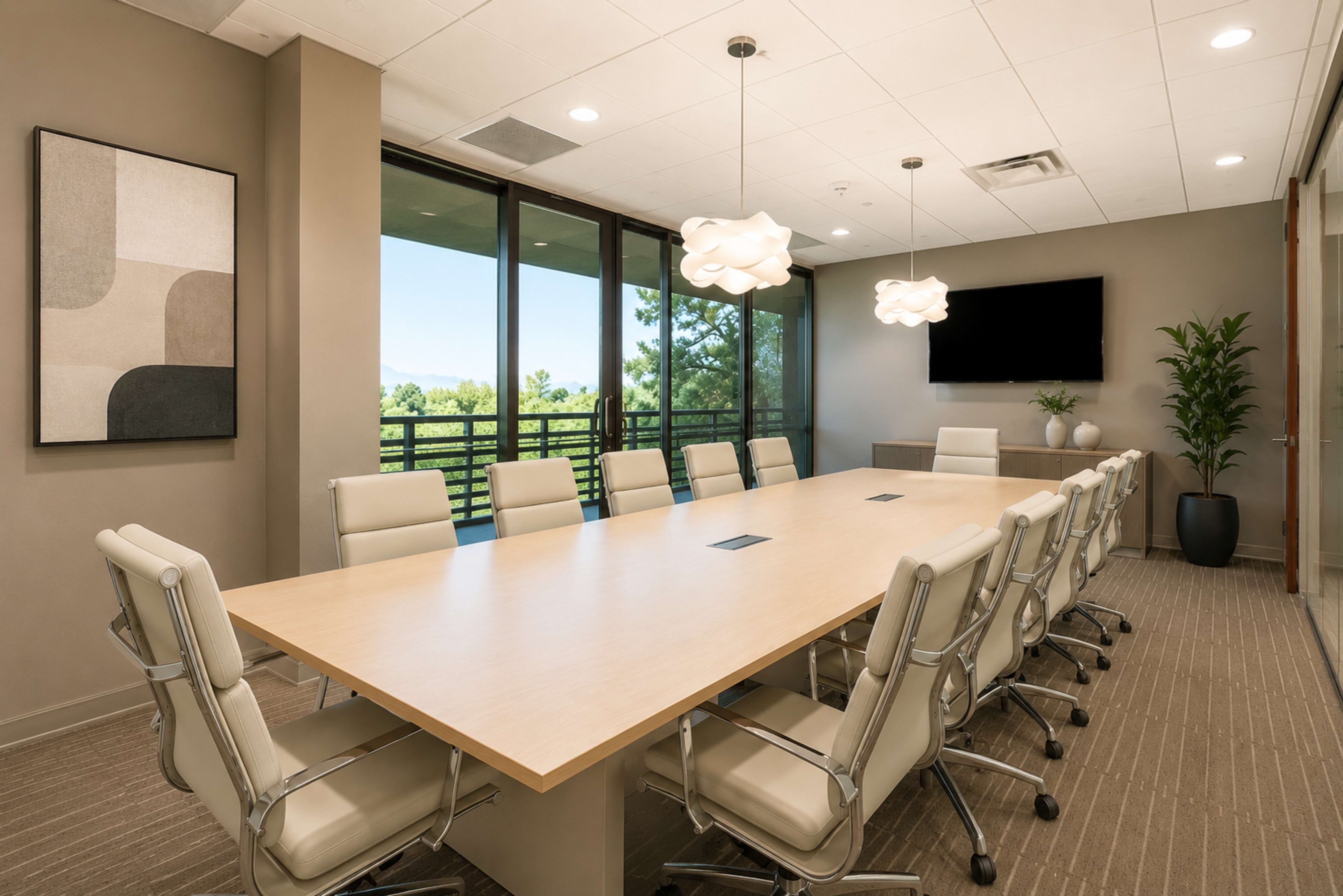 A modern conference room features a large wooden table surrounded by white leather chairs, with three pendant lights overhead and a wall-mounted TV.
