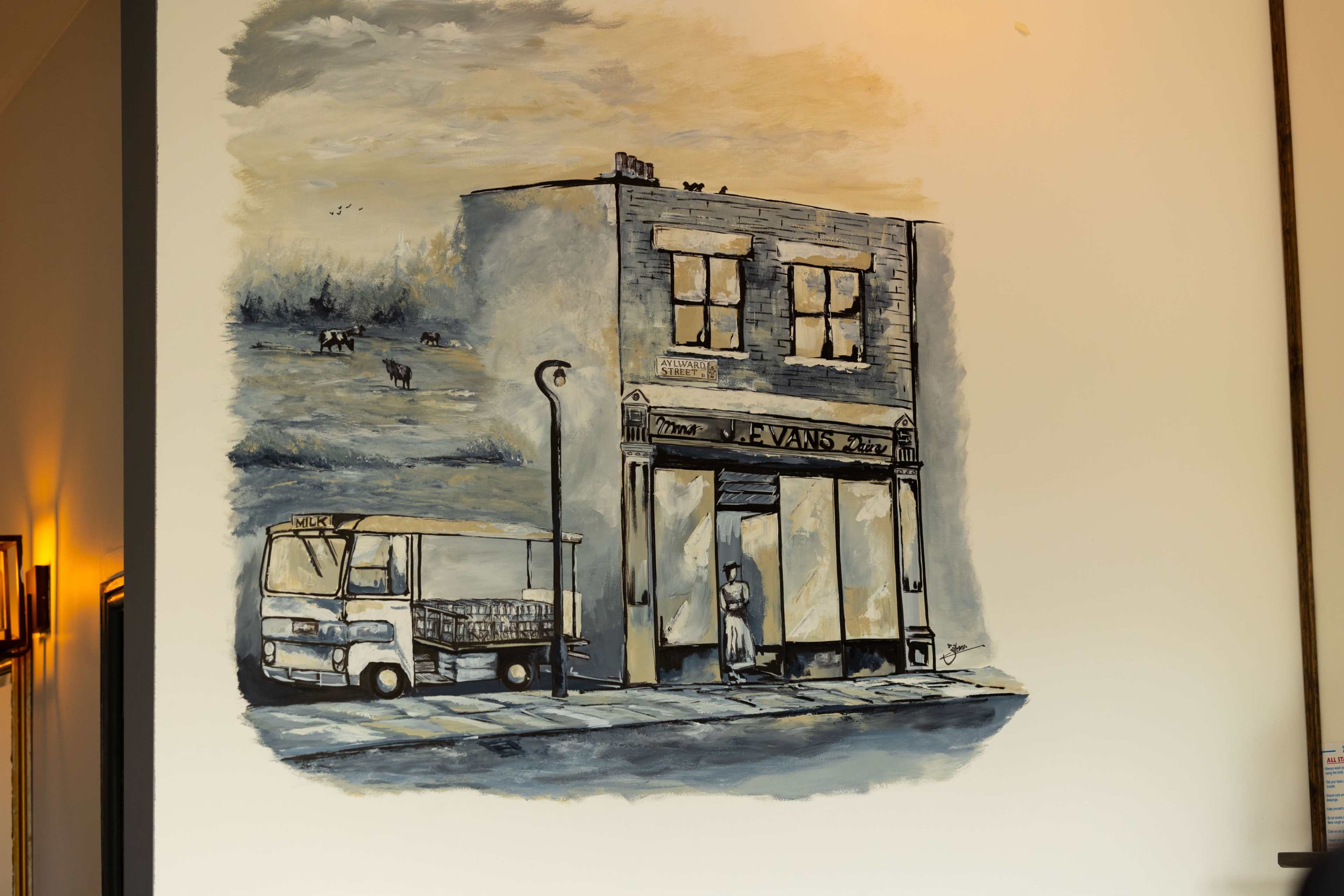 A wall mural of a storefront with a parked truck outside, illustrating a scene of urban life.
