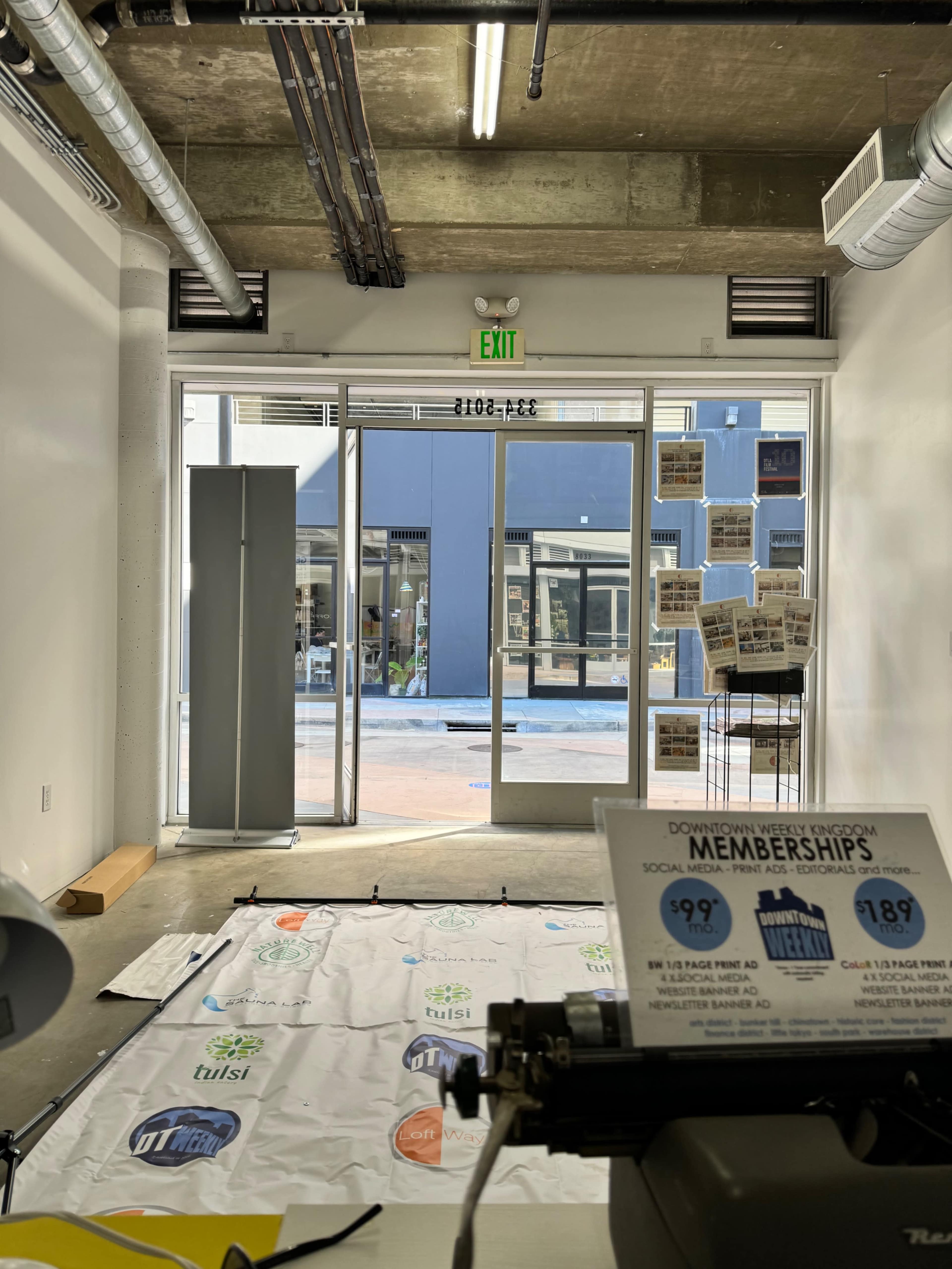 A view from inside a business looking out towards a courtyard area, with a sign for memberships visible in the foreground.