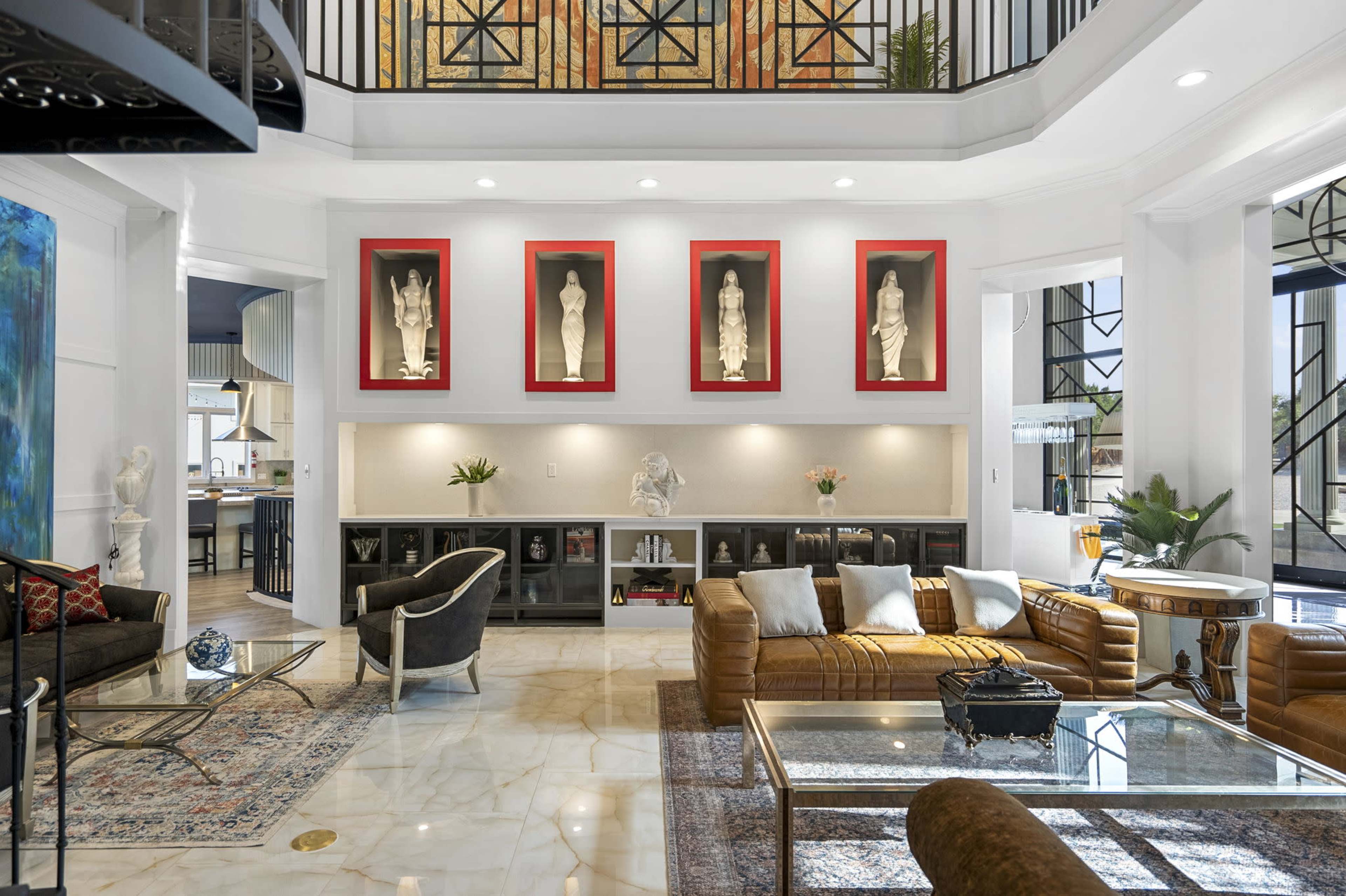 A spacious living room features elegant furniture, framed sculptures on the wall, and modern decor.