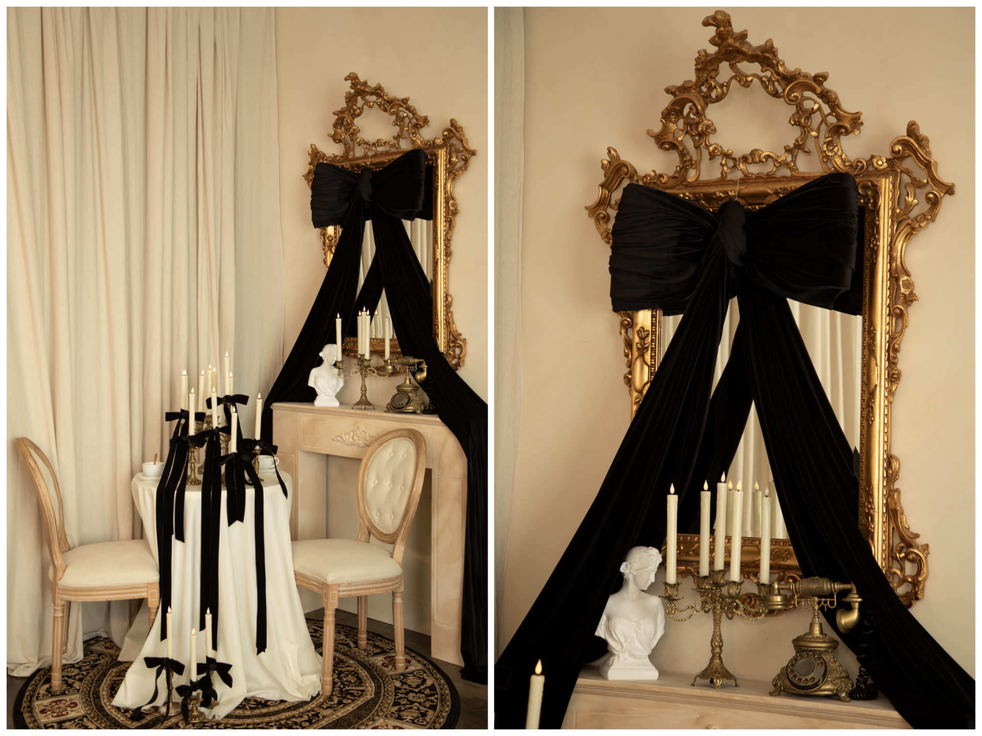 The scene features an elegantly decorated room with a mirror framed in ornate gold, a table set with white and black drapery, and candles arranged on the surface.