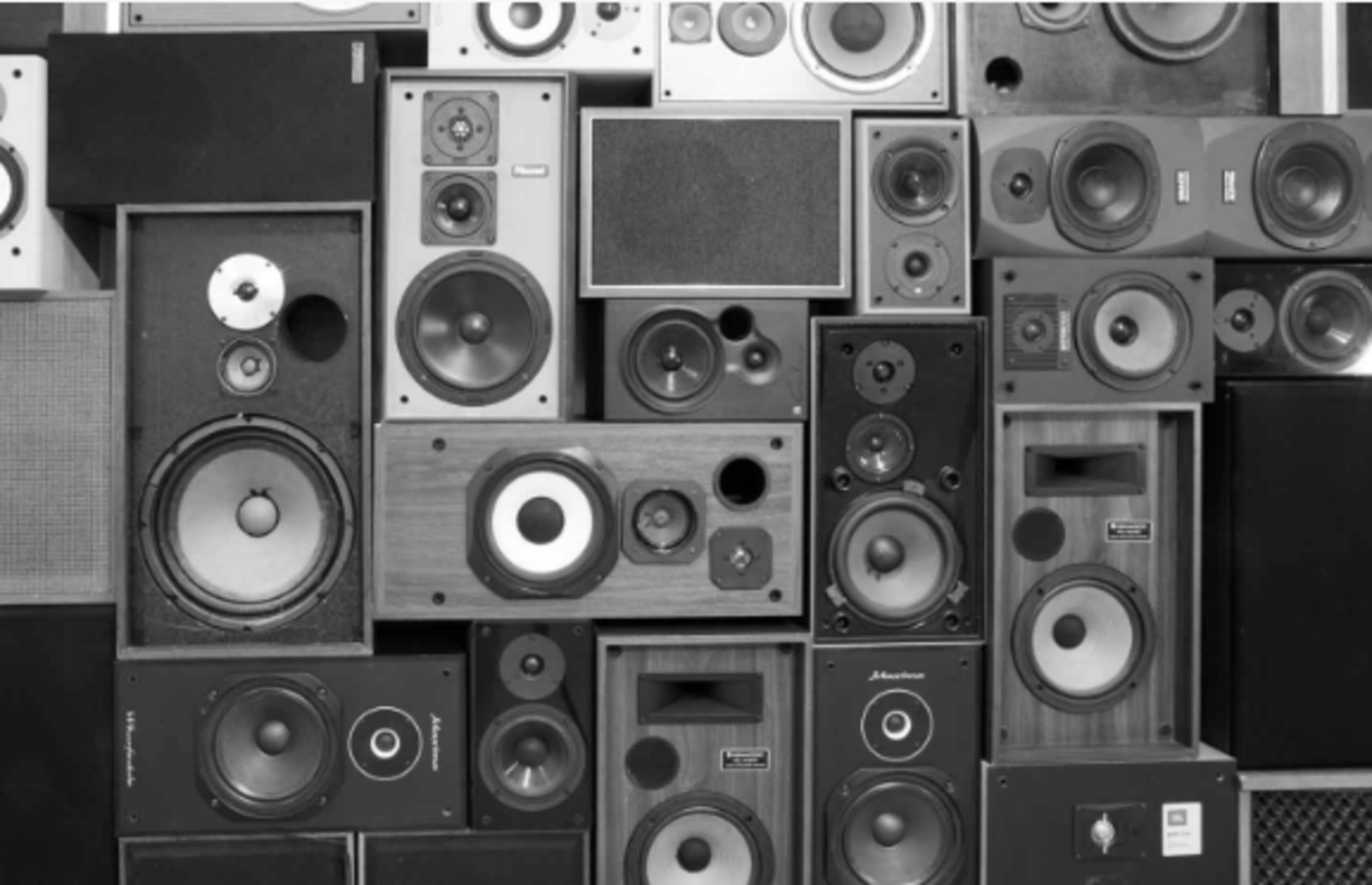 The image features a collection of various vintage and modern speaker cabinets arranged in a grid pattern.