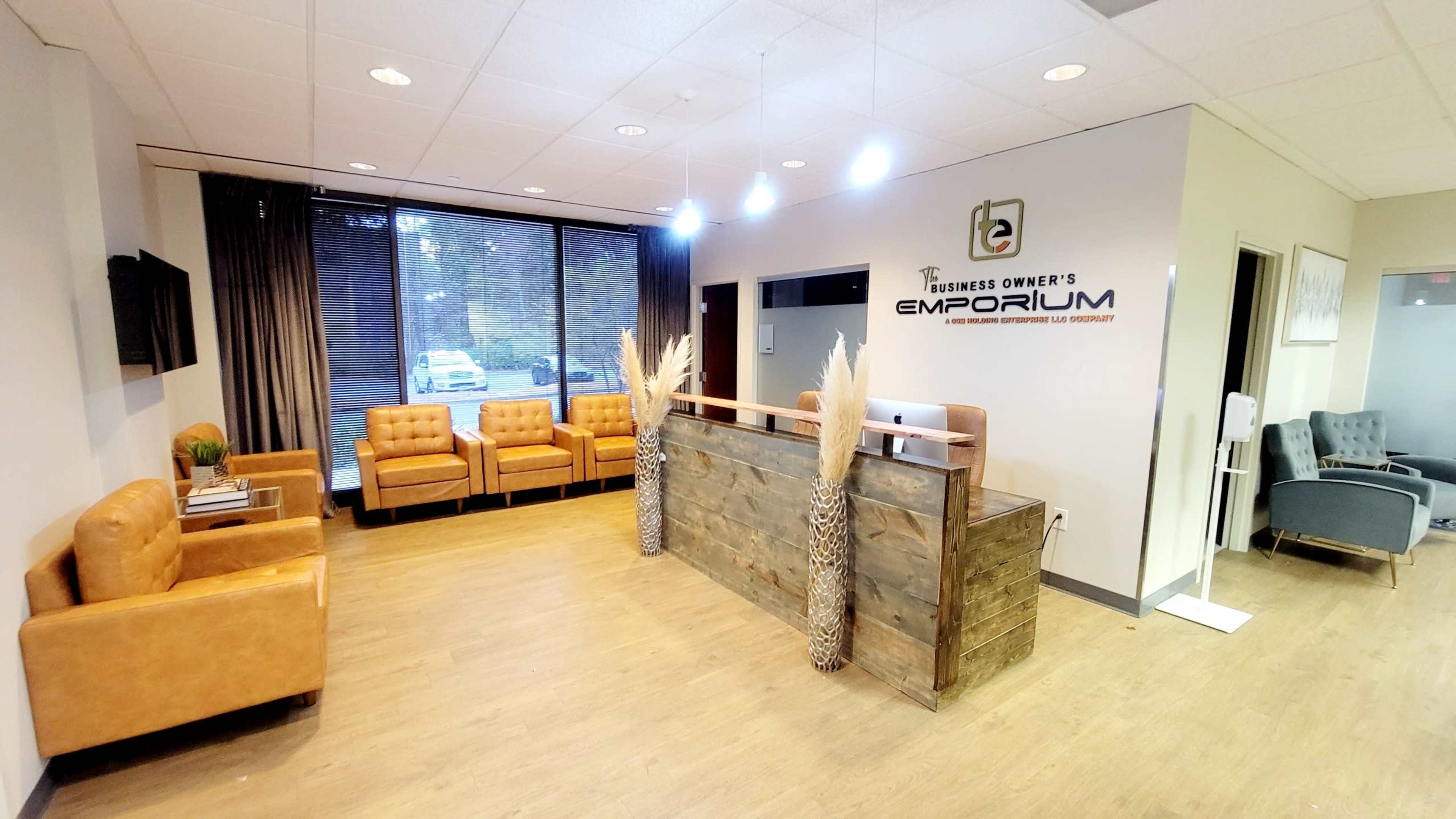 A modern reception area featuring brown leather chairs, a wooden reception desk, and large windows with curtains.