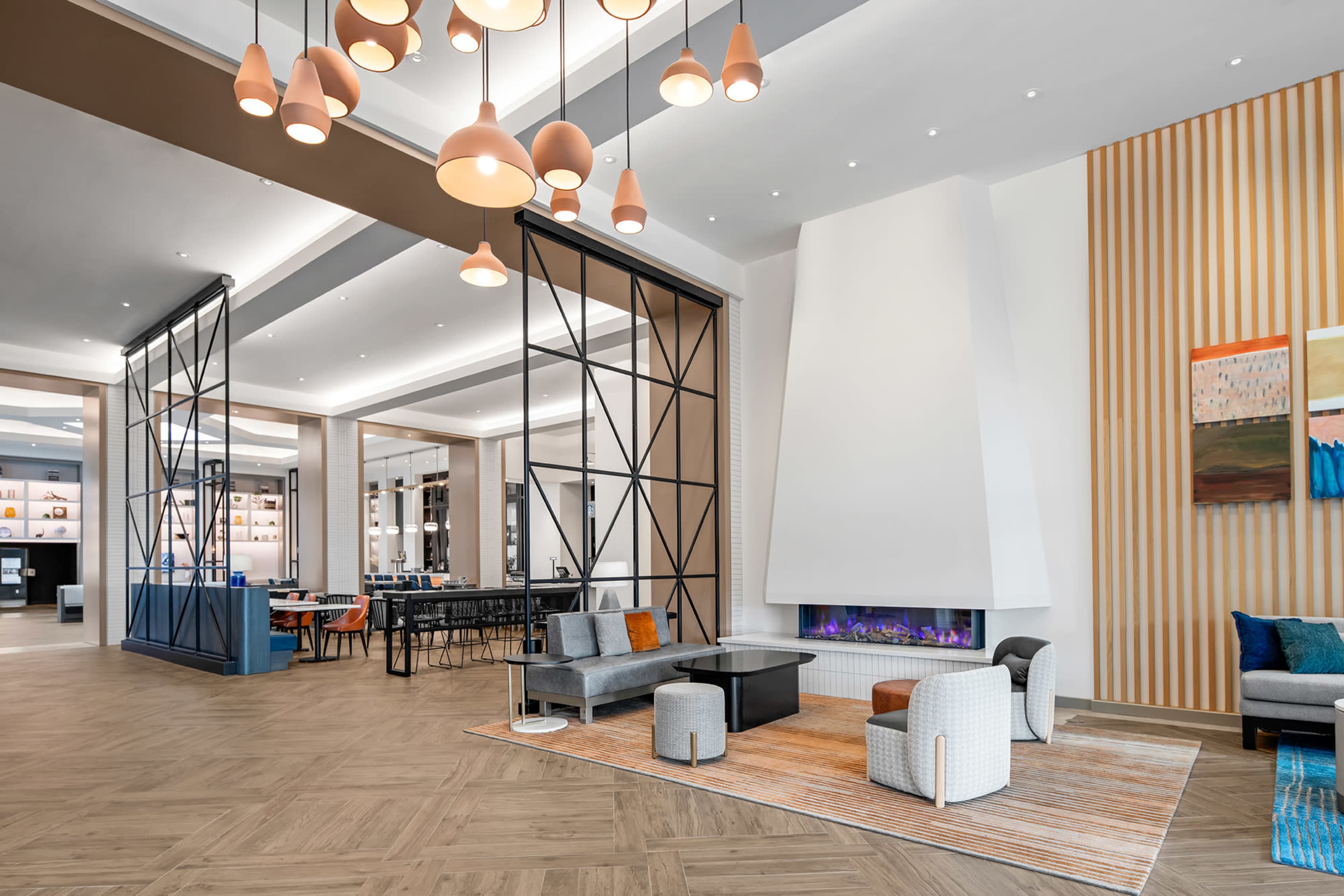 A modern hotel lobby featuring a fireplace, various seating options, and decorative lighting.
