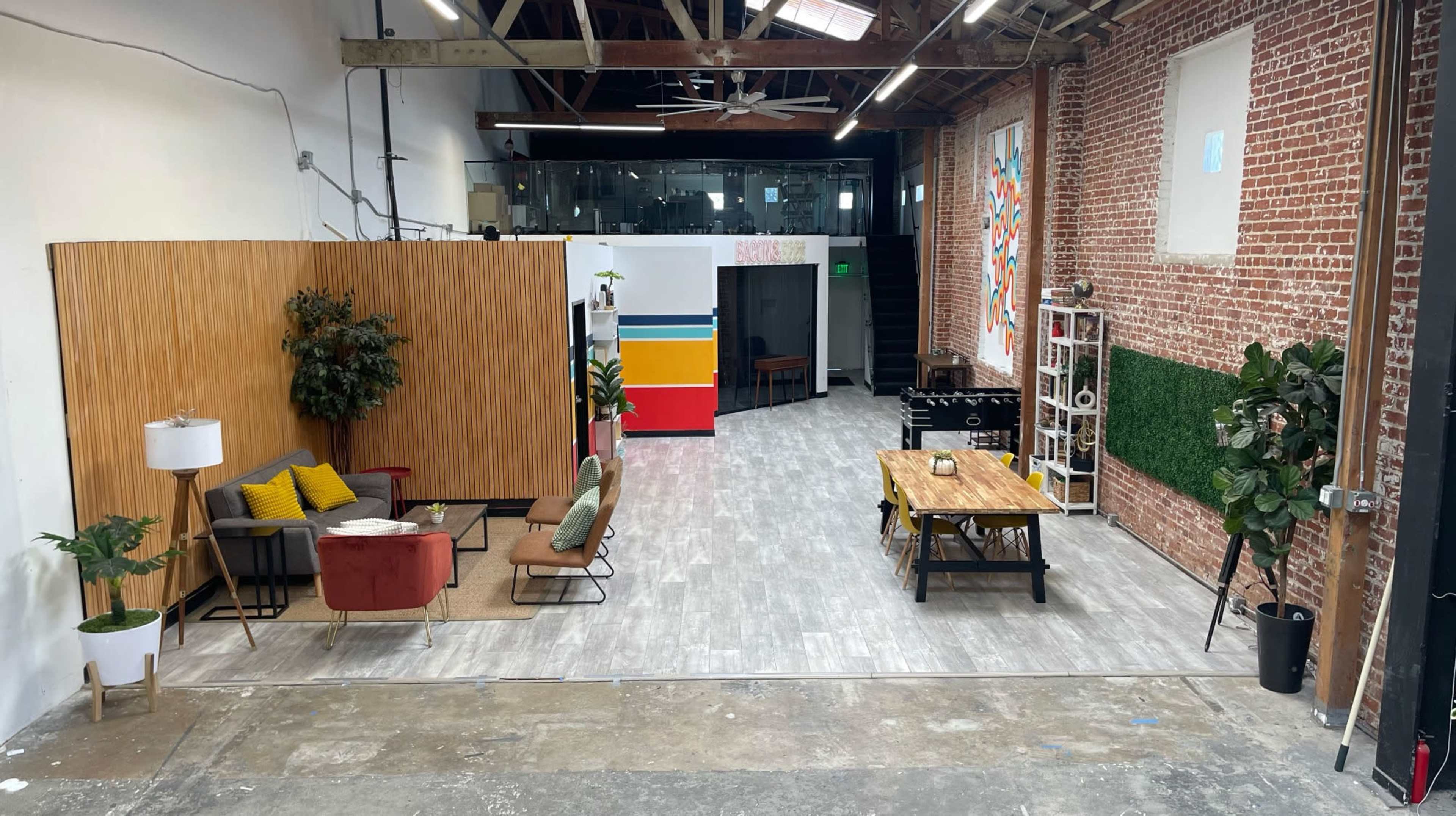 A spacious interior with wooden accents, a seating area featuring various chairs and a table, and vibrant wall decorations.