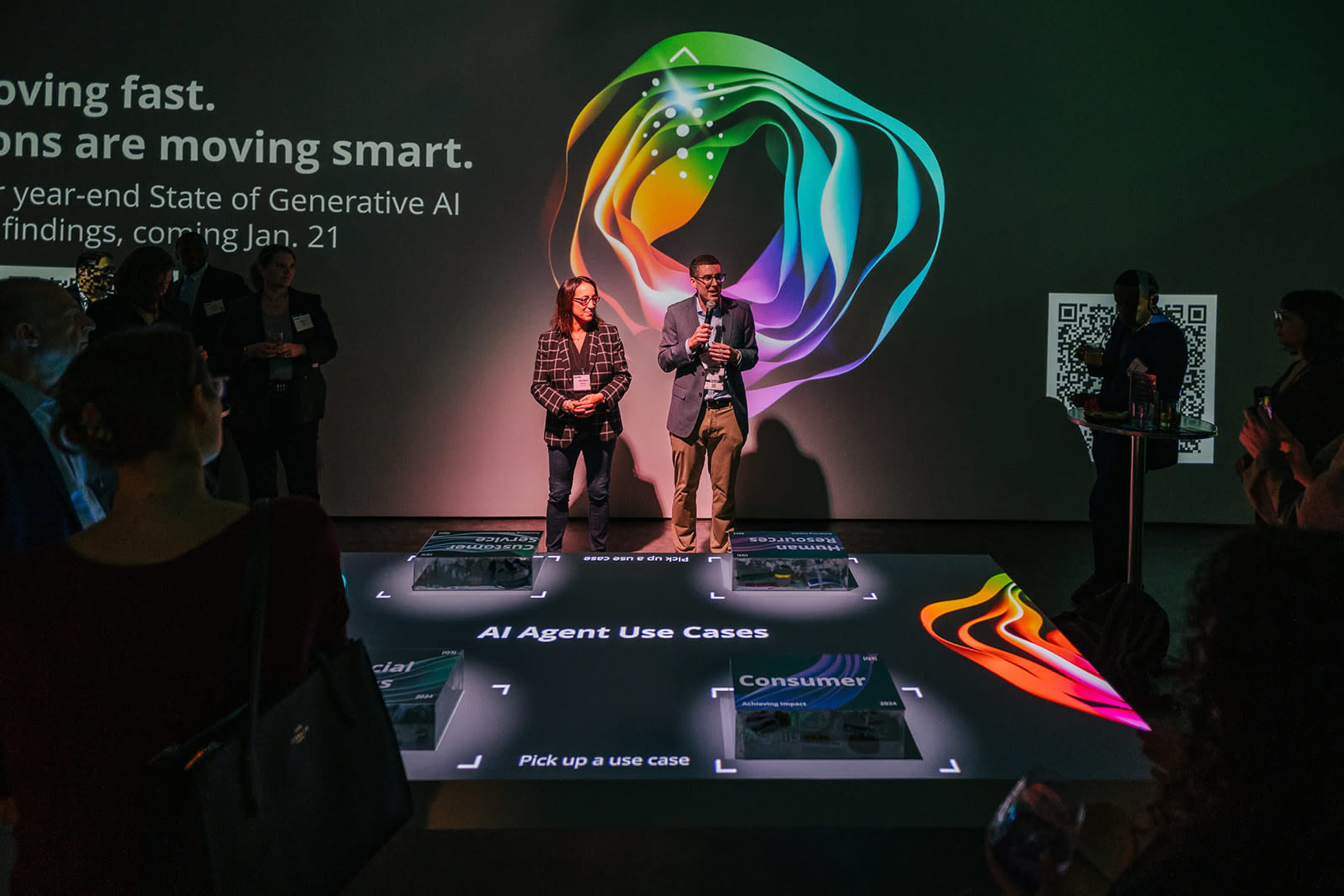 A presentation featuring two speakers discussing generative AI, with colorful graphics displayed on the floor.