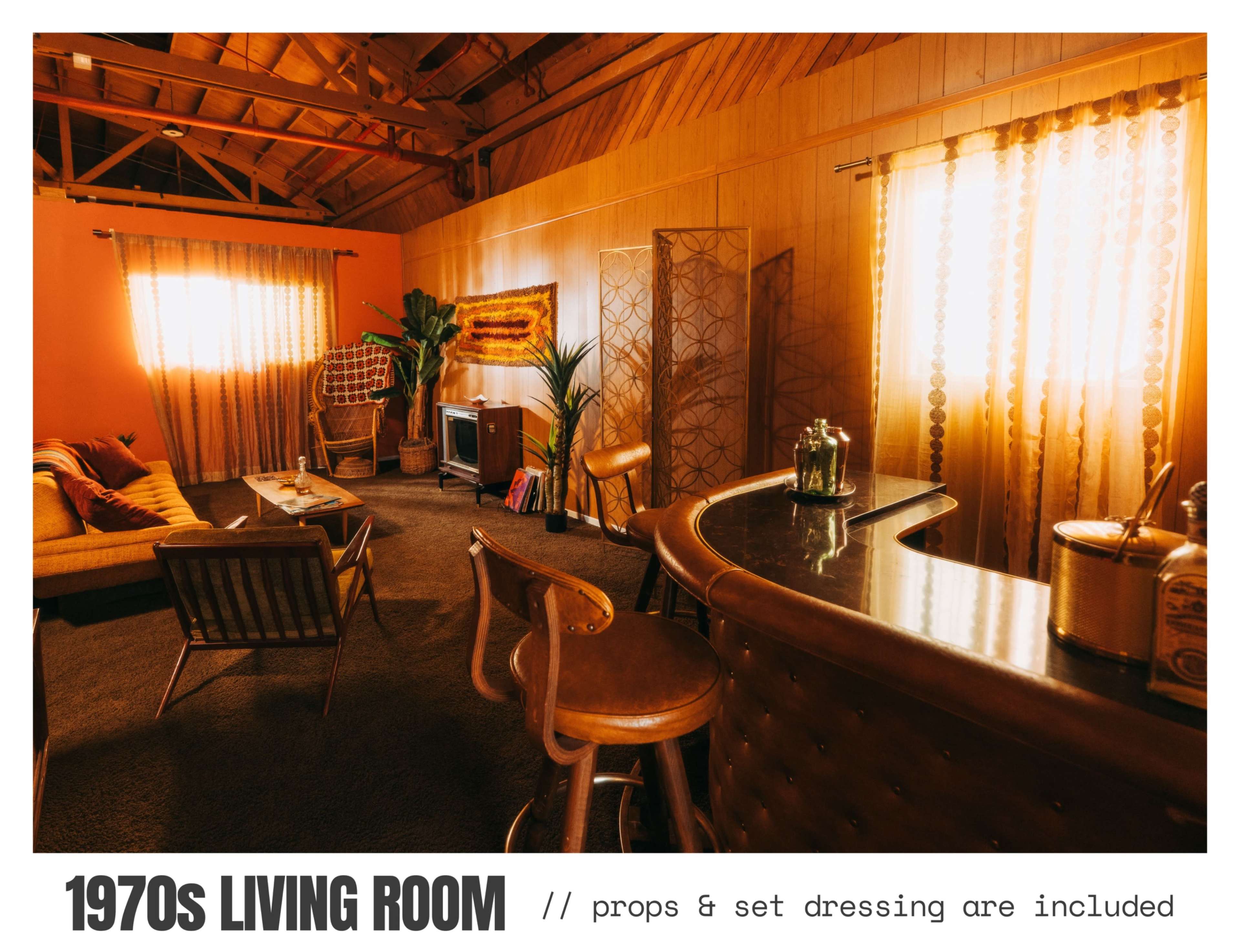 The image depicts a 1970s-style living room with retro furniture, a bar area, and warm-toned décor.