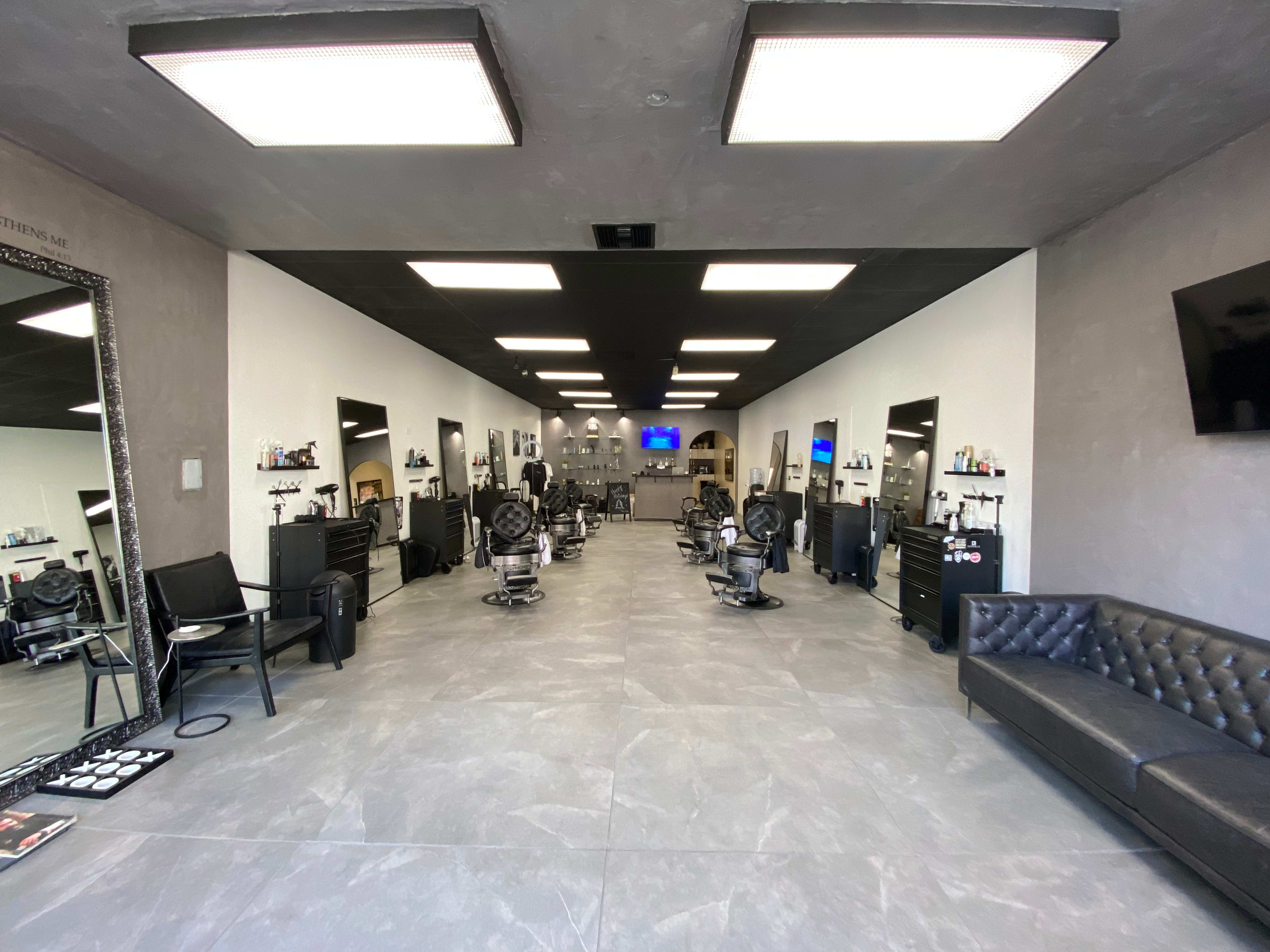A modern hair salon with several styling chairs, mirrors, and a waiting area.