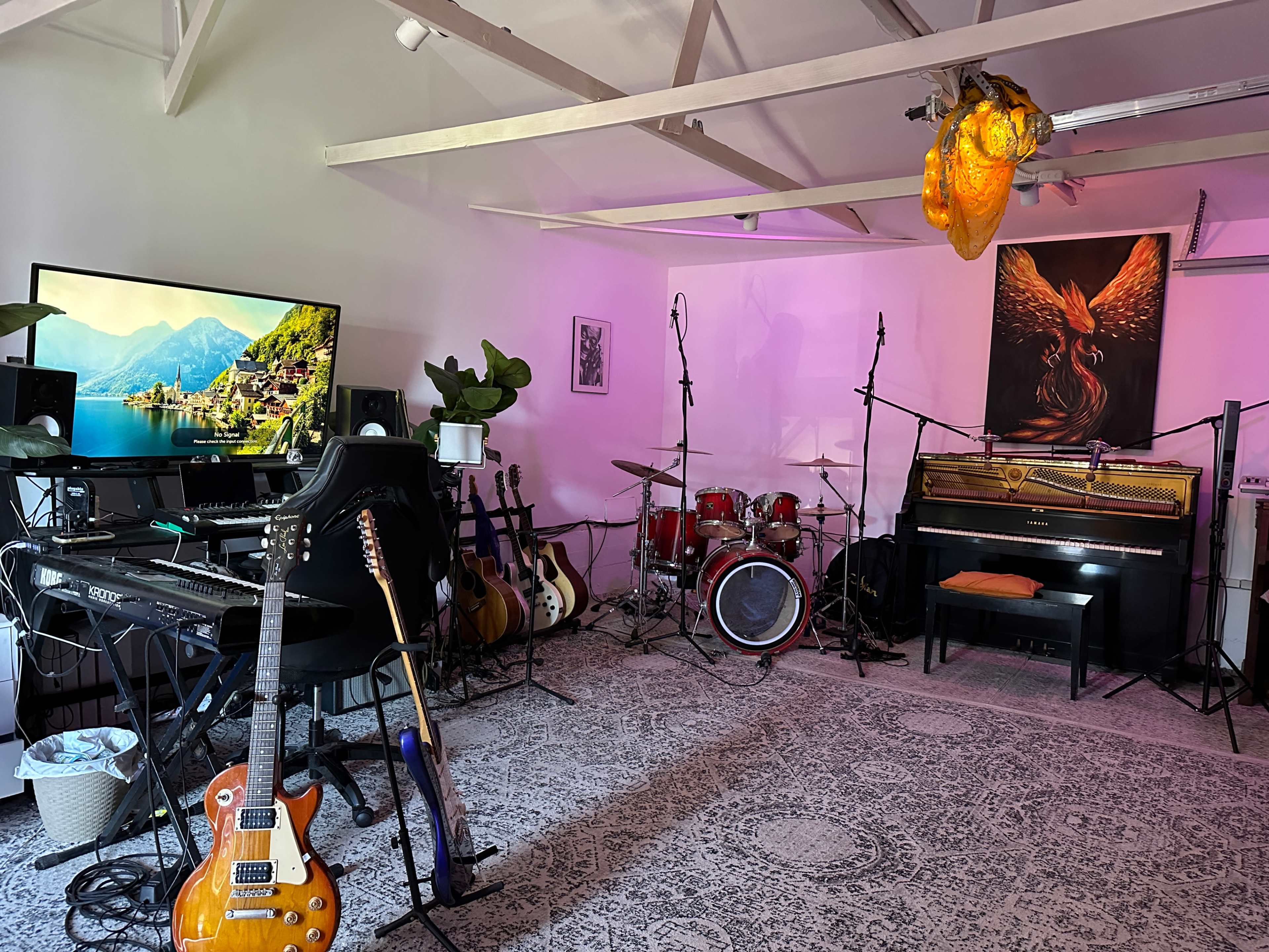 A music studio is equipped with various instruments, including guitars, a keyboard, a drum set, and a grand piano, alongside a large television and artistic decor.