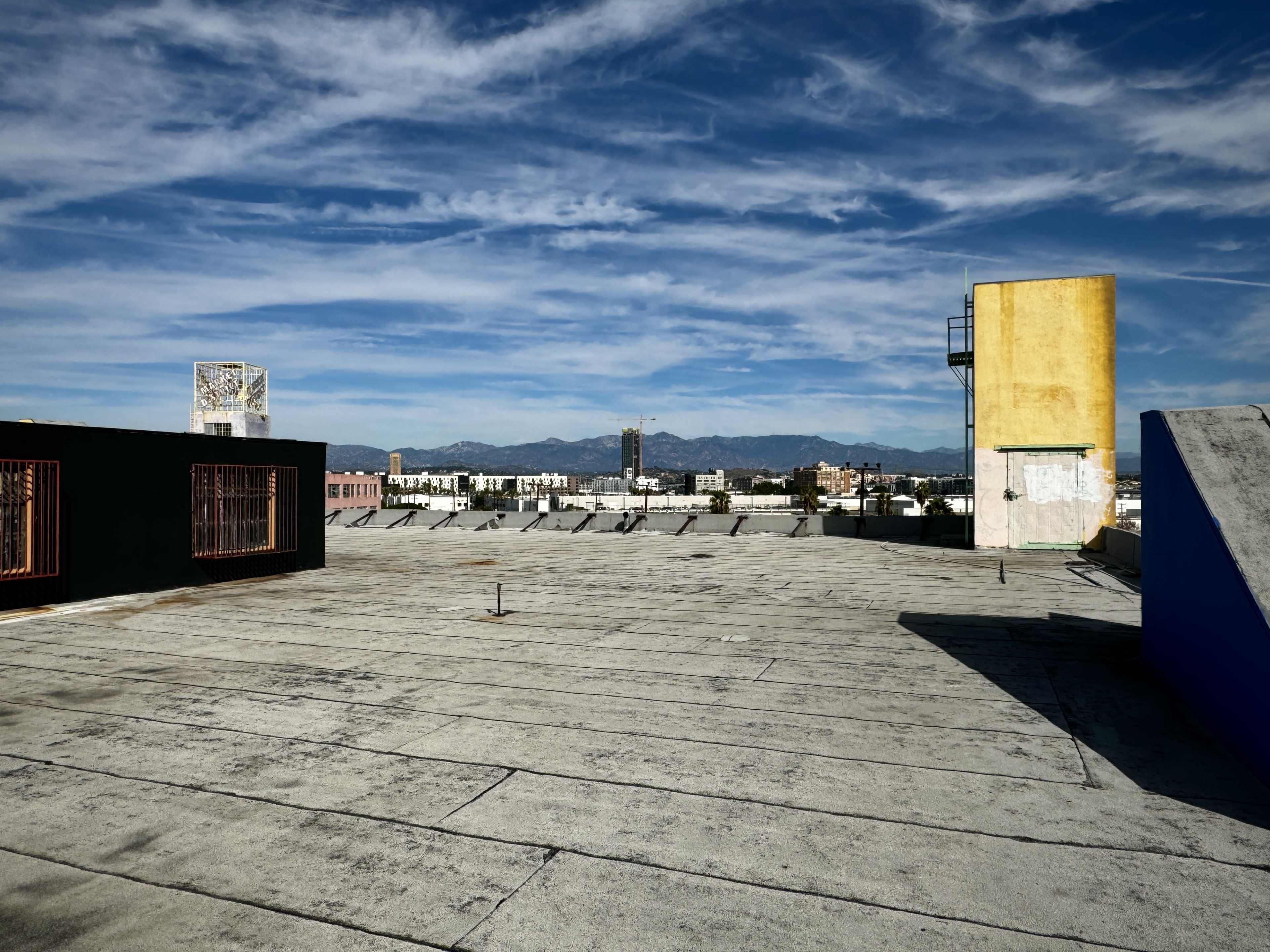 A flat rooftop with a clear sky and distant mountains in the background.