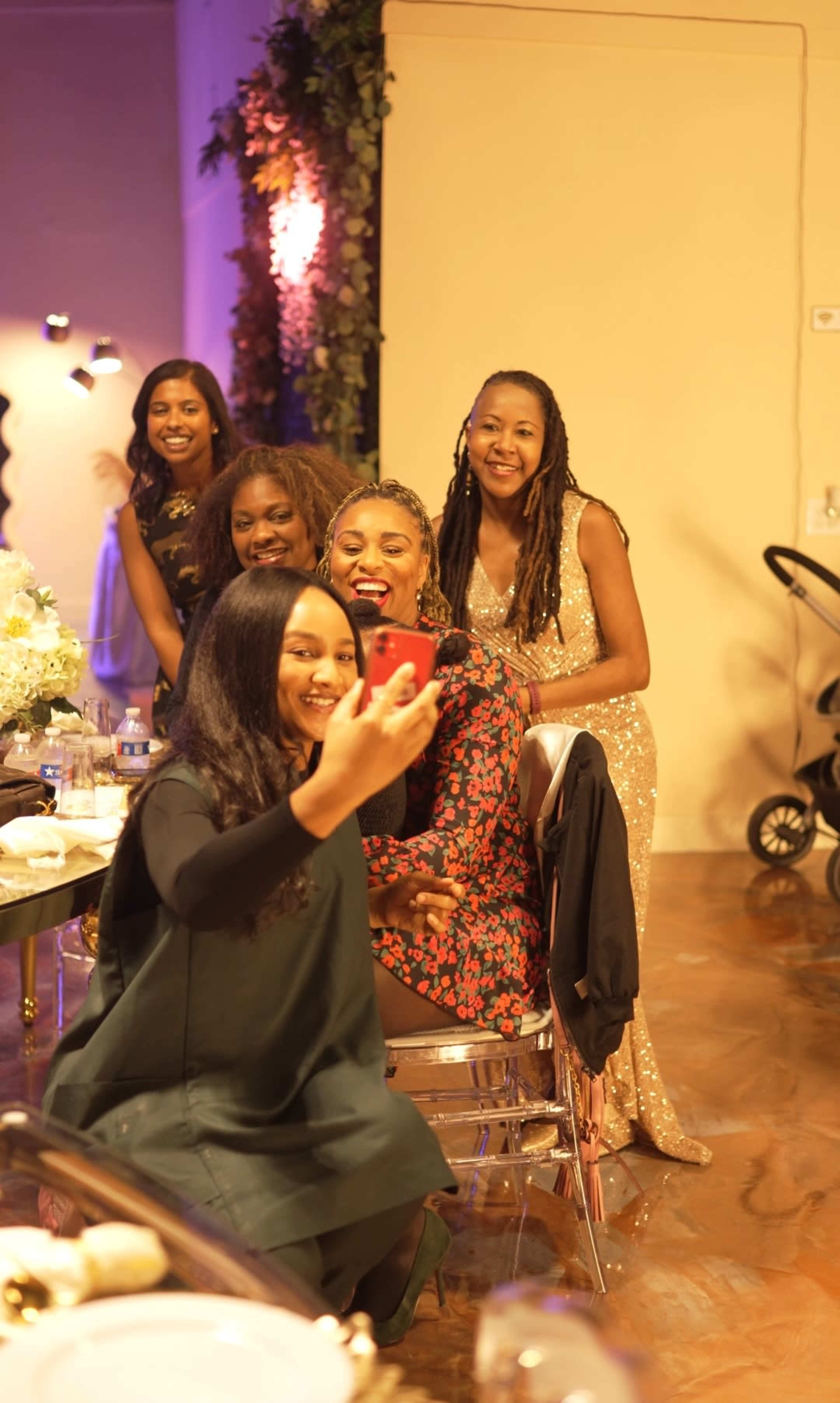 A group of five women poses for a selfie at a social event, smiling and enjoying the moment.