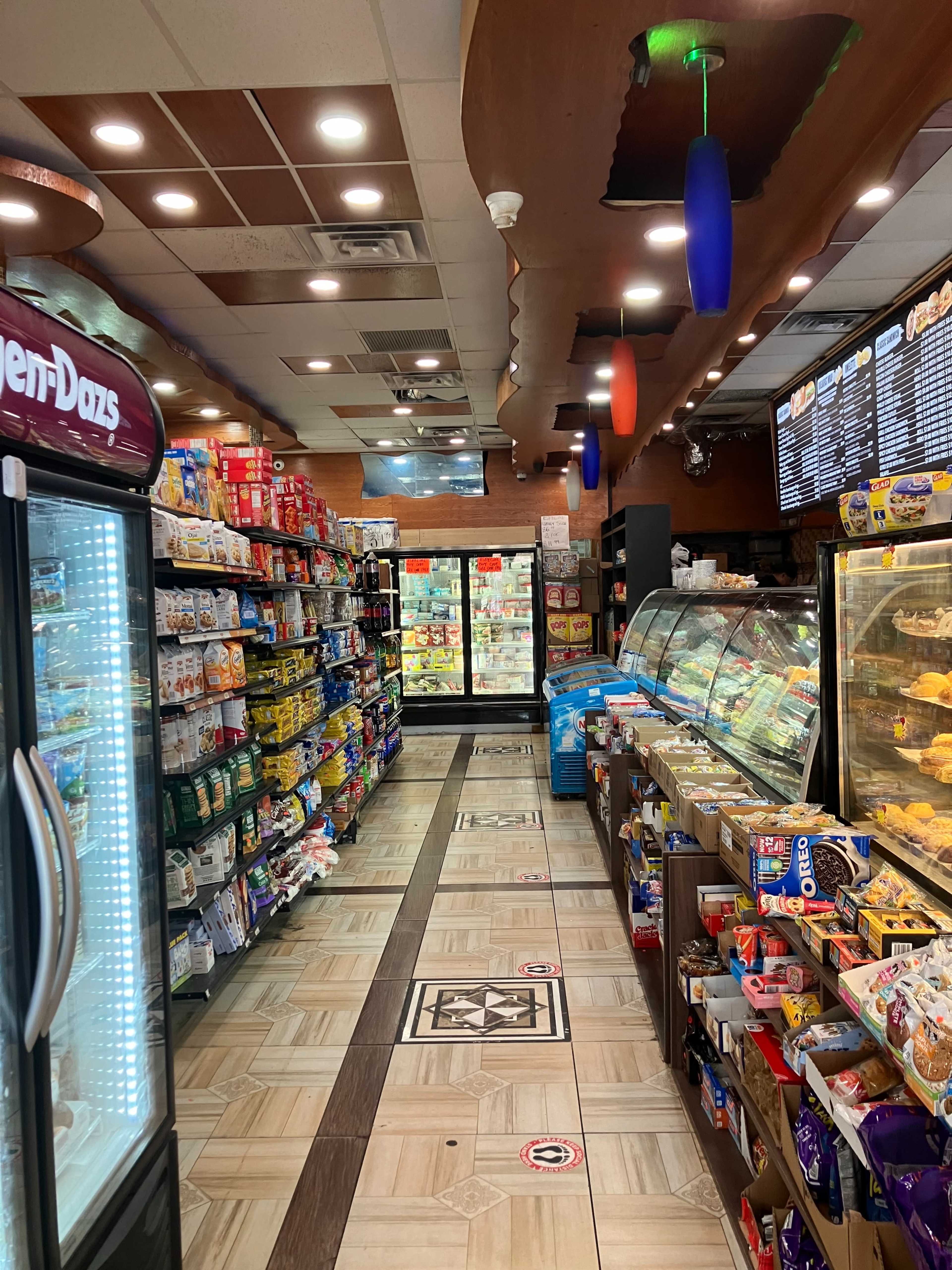 The interior of a convenience store with aisles stocked with various food and beverage items on both sides.