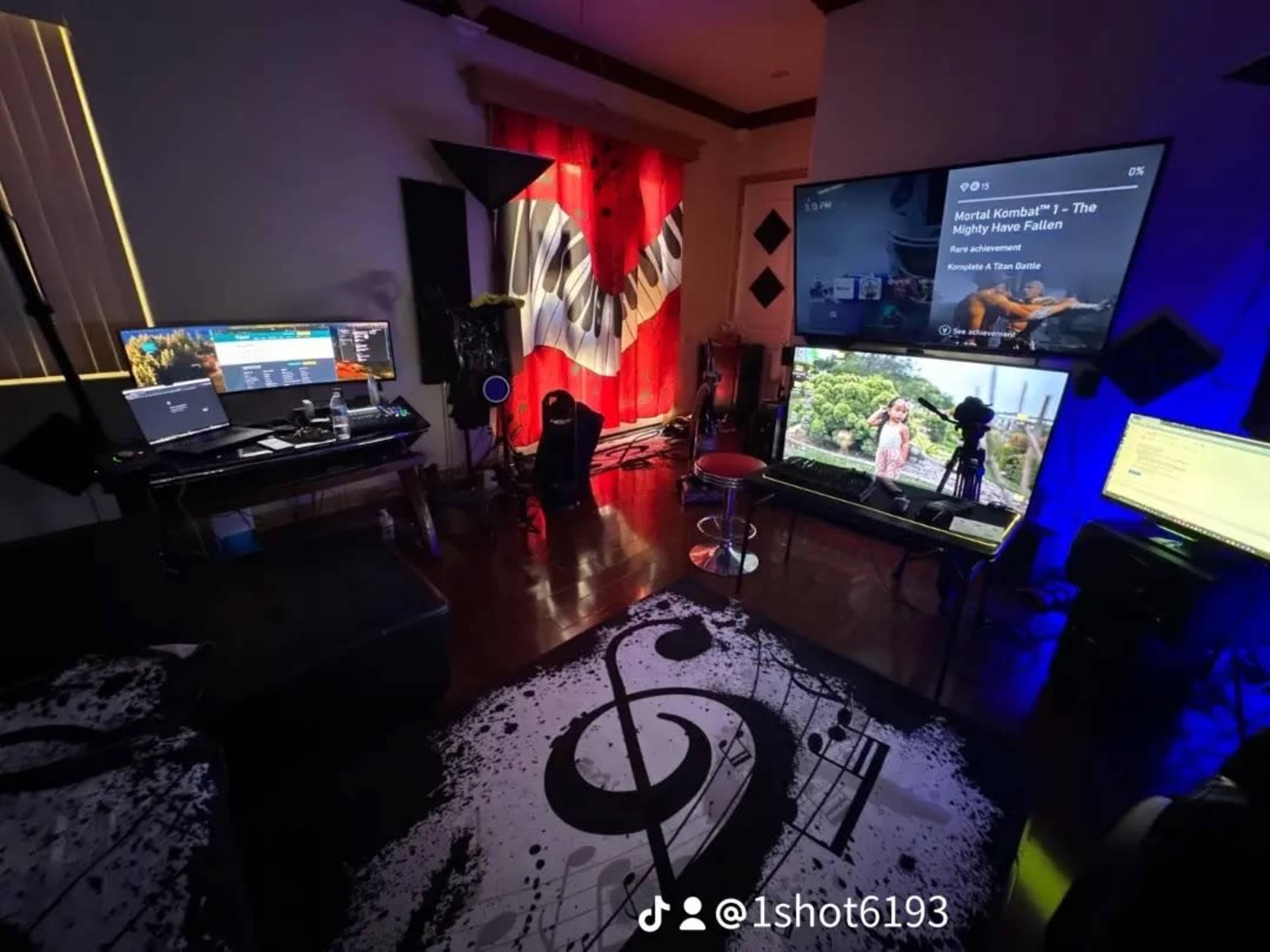 The image shows a colorful home entertainment setup with multiple screens, a musical note-patterned rug, and red curtains in a room.