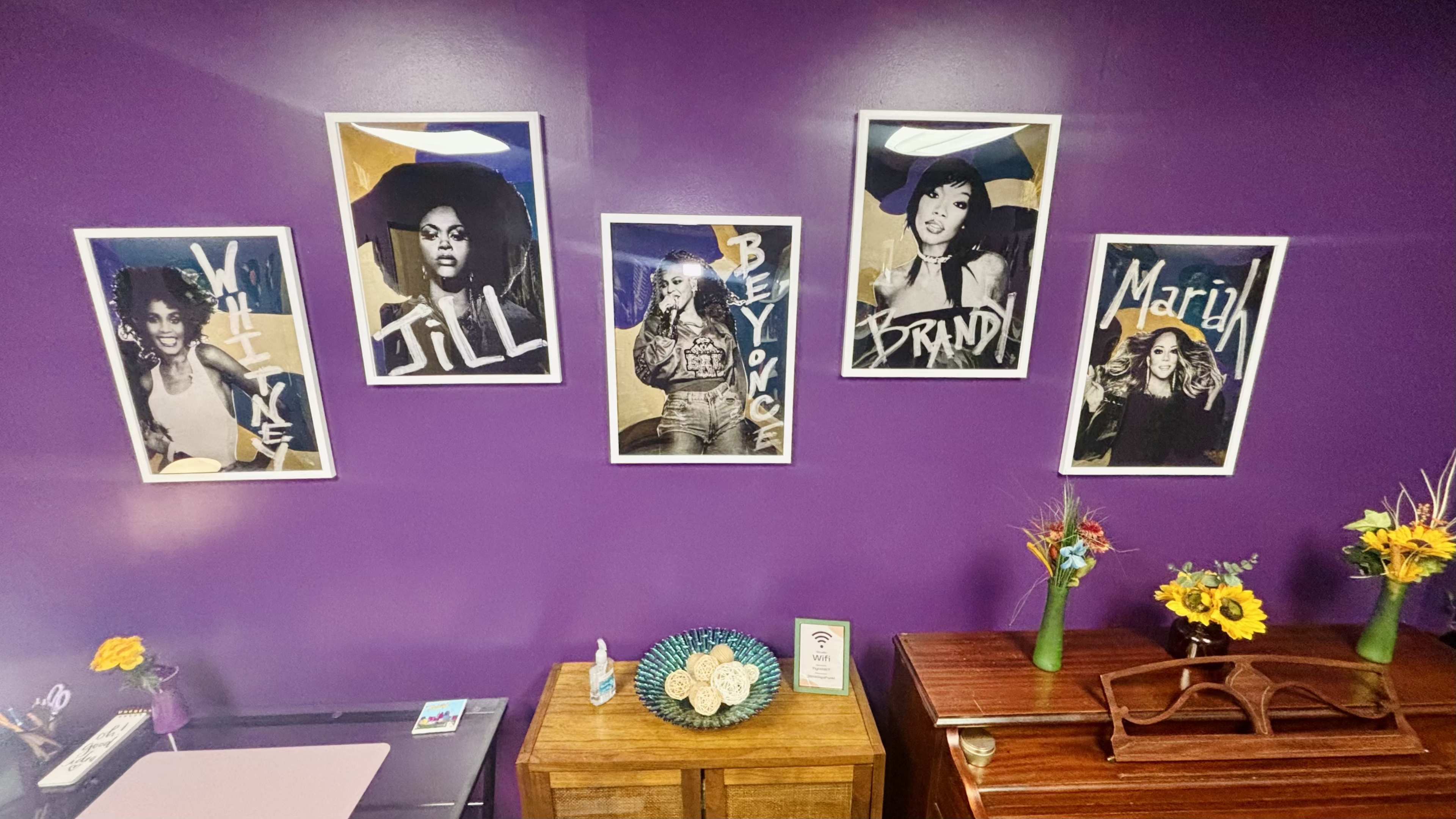 The image displays five framed portraits of women with bold names written in an artistic style against a purple wall.
