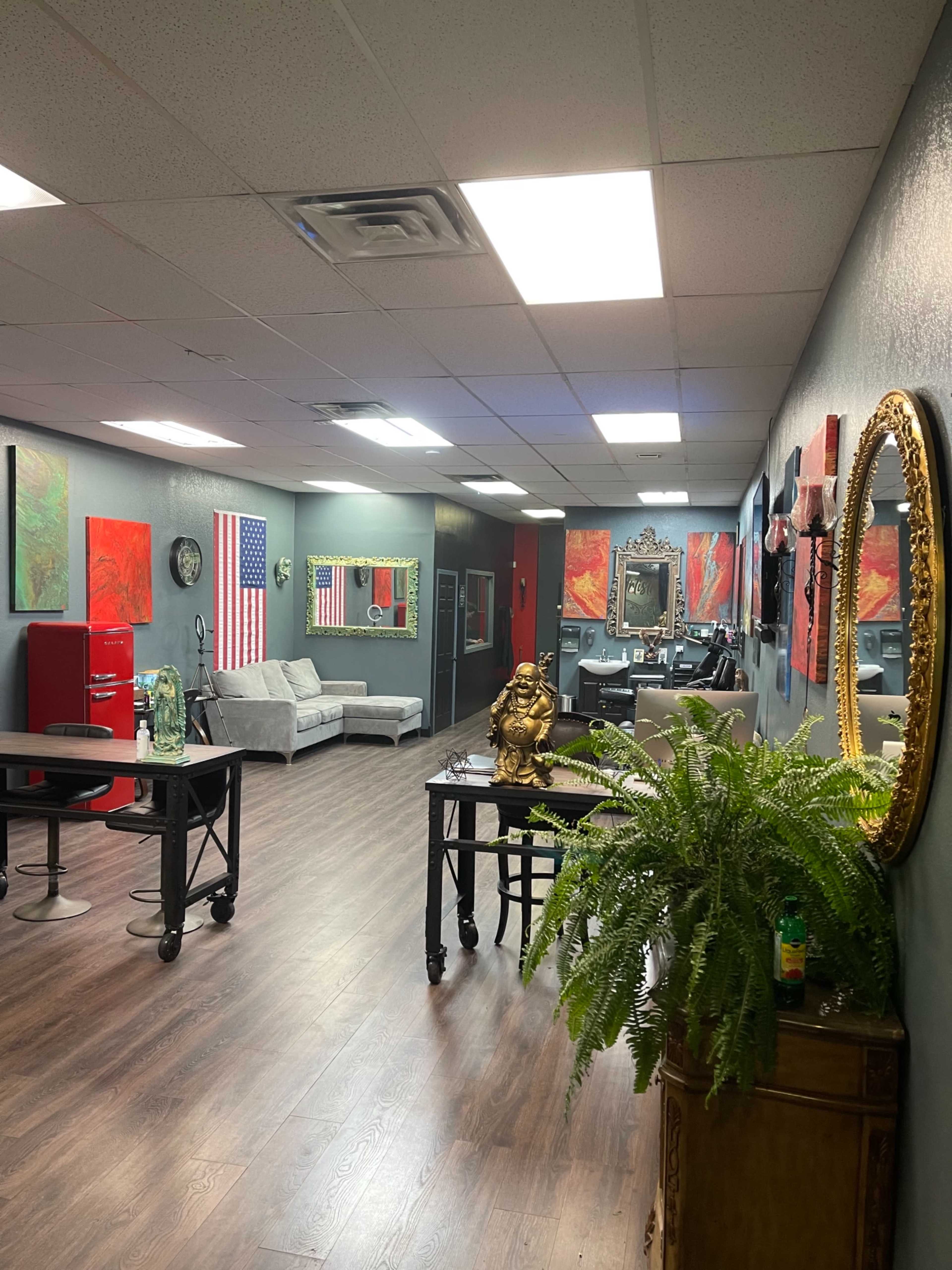 A spacious interior with a reception area featuring two couches, artwork on the walls, and a decorative mirror.