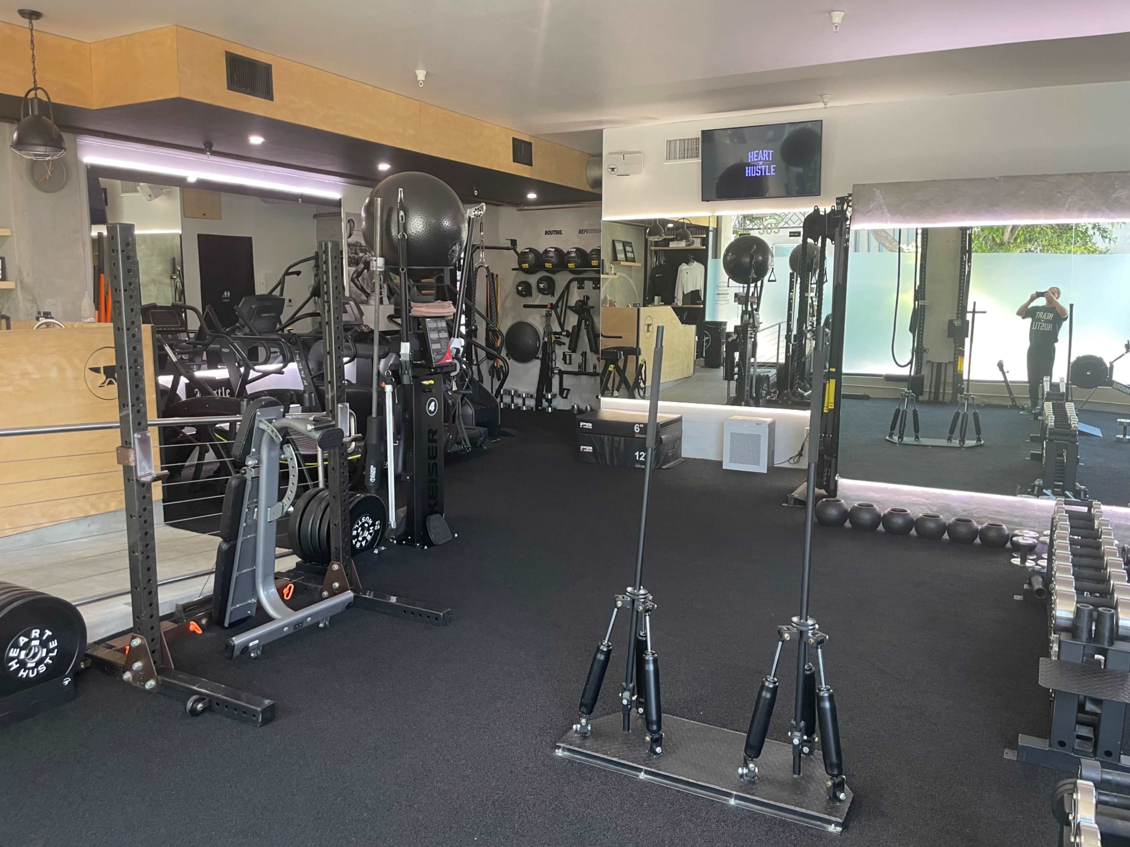 A well-equipped gym interior featuring various exercise machines, weights, and workout stations.