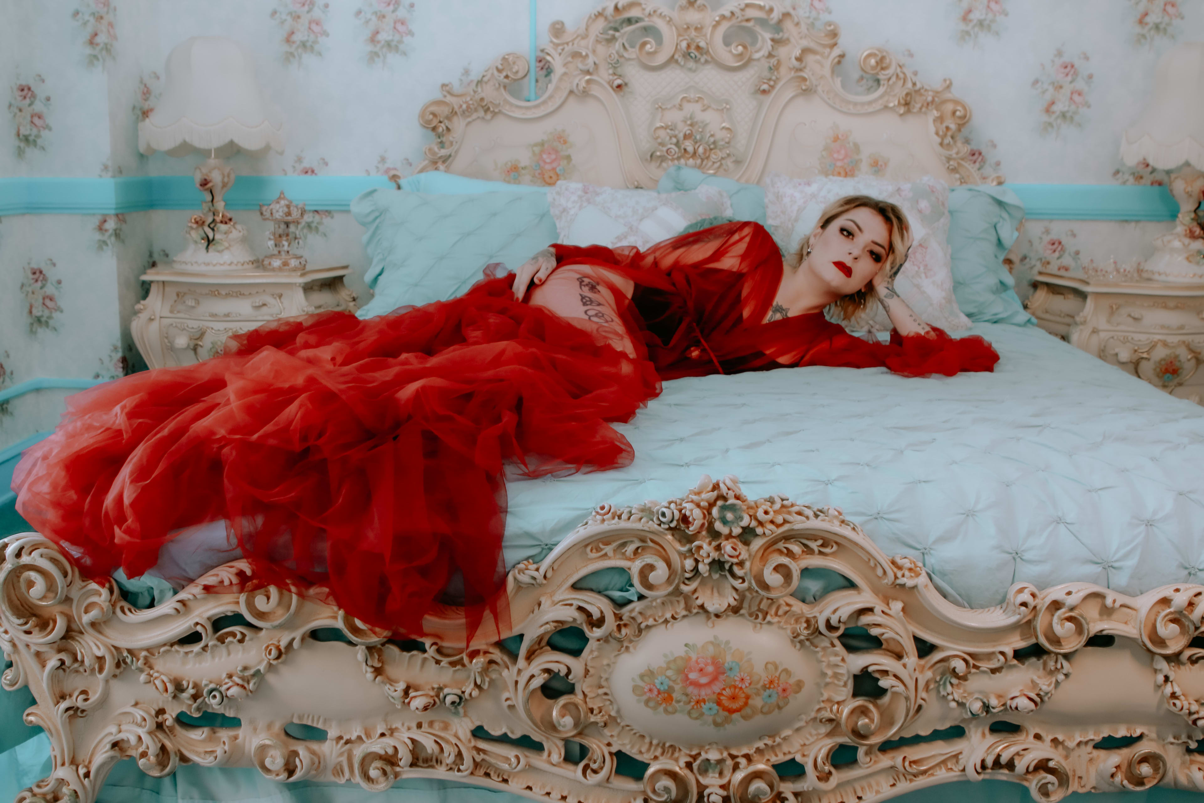 A woman in black and red lingerie posing for a boudoir photoshoot.