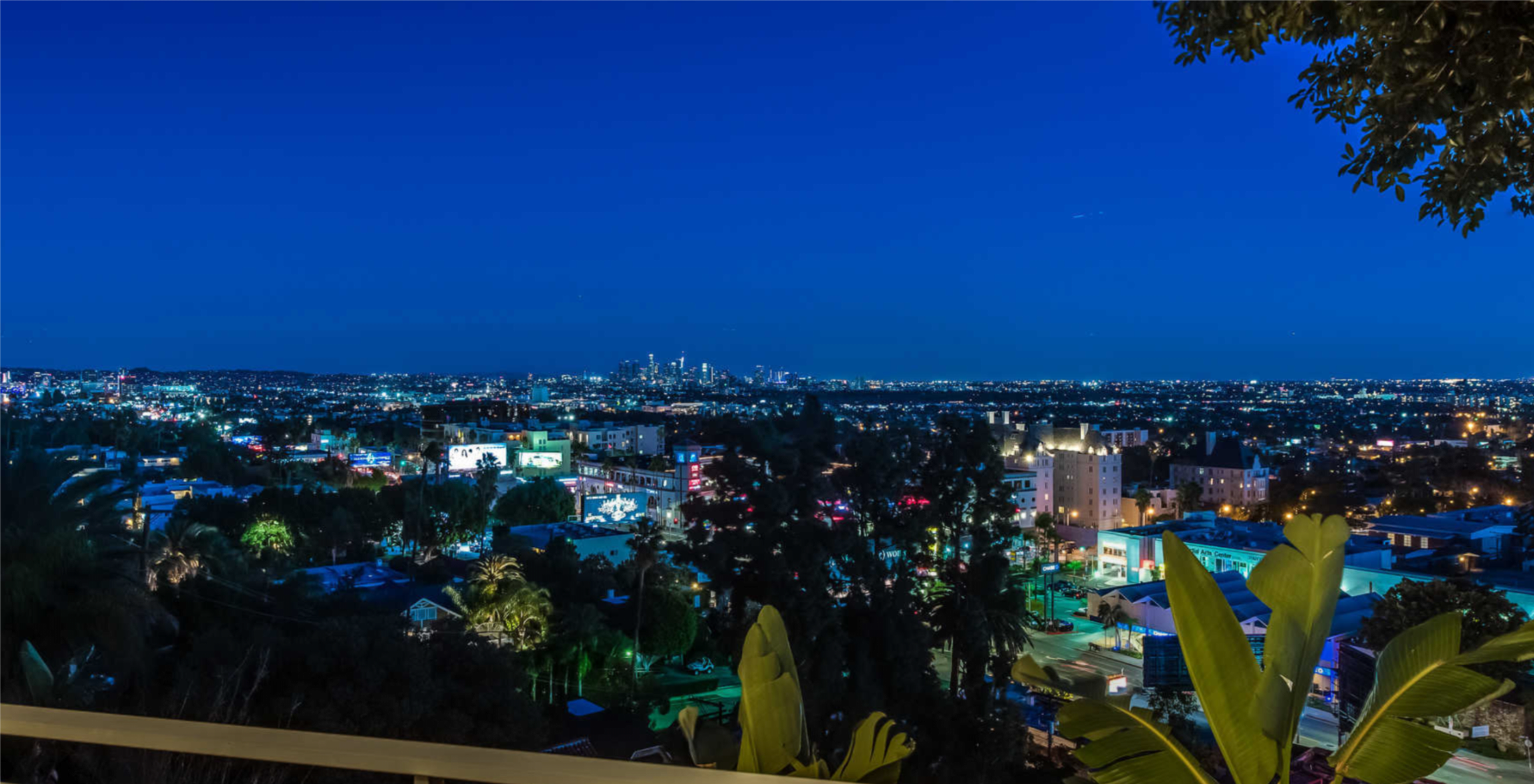 The image shows a nighttime view of a city skyline with illuminated buildings and streets.