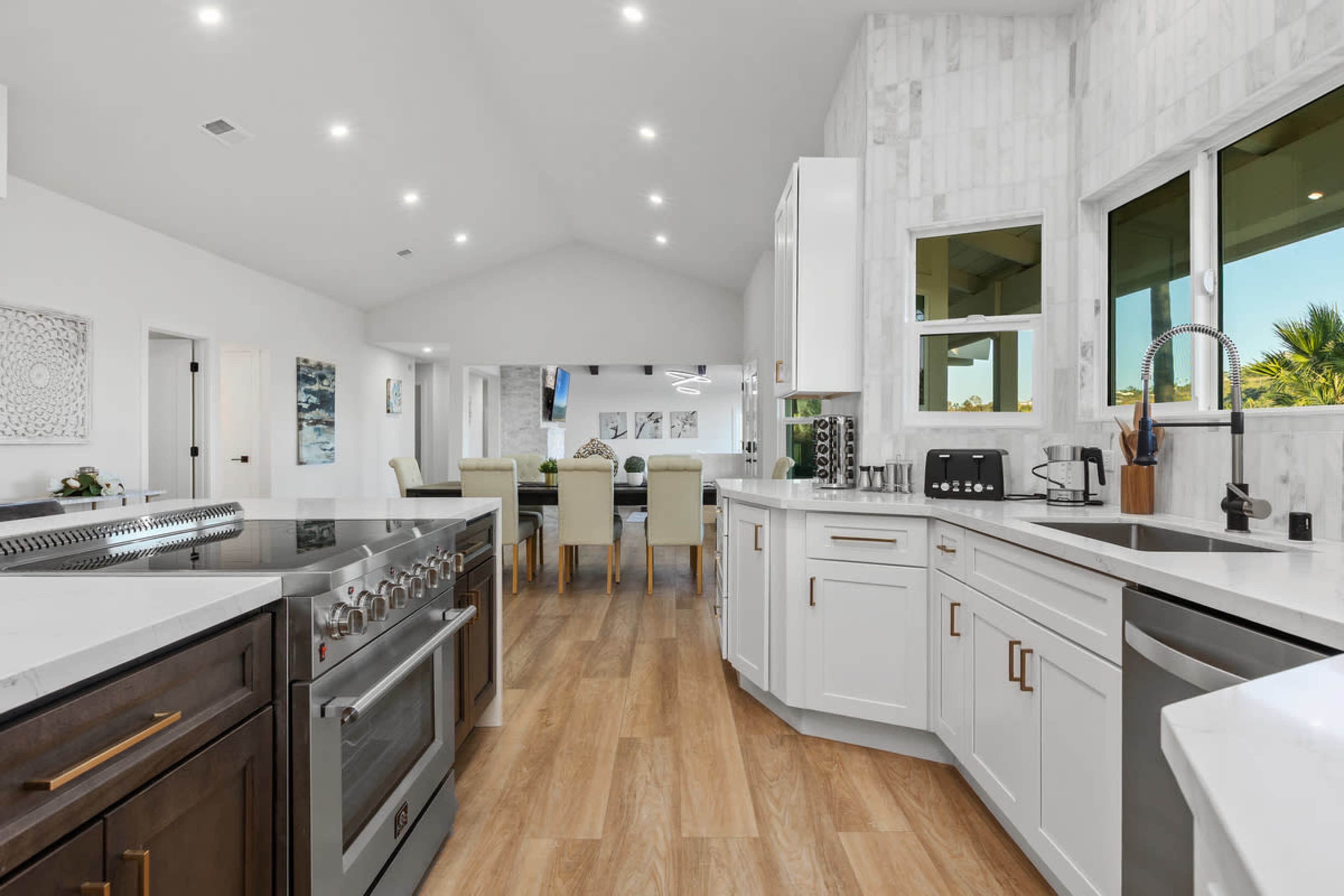 The kitchen features modern cabinetry, stainless steel appliances, and a spacious layout with wood flooring.