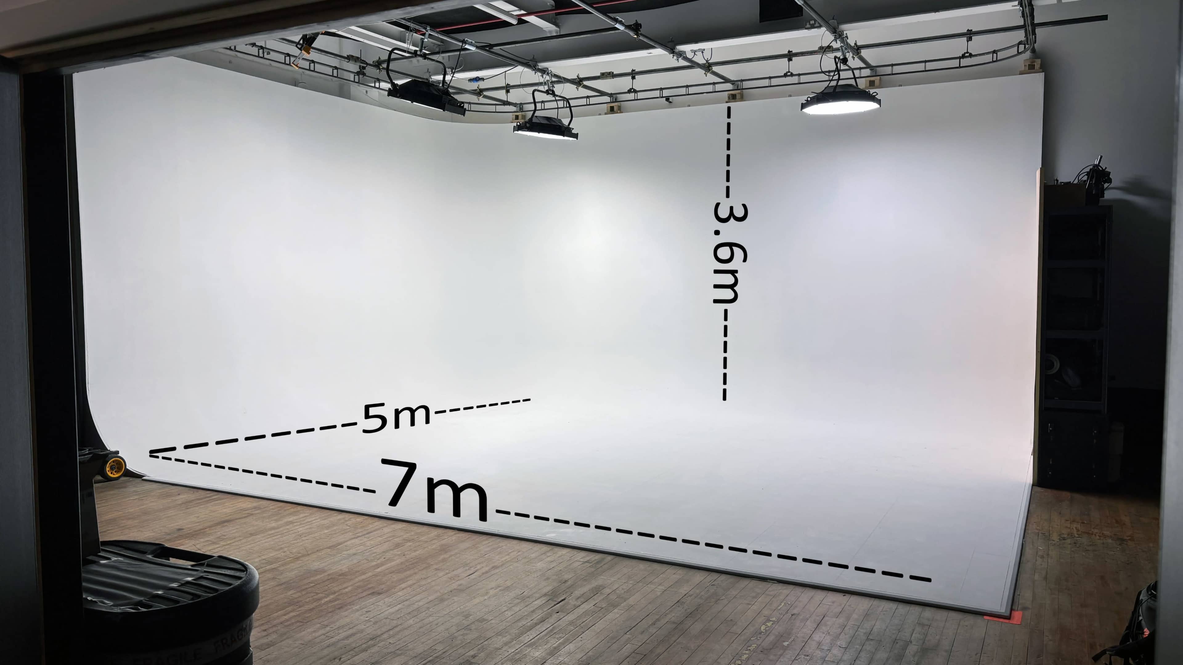 The image shows a large photography studio with a white backdrop, measuring 7 meters in width and 5 meters in depth, and a height of 3.6 meters.