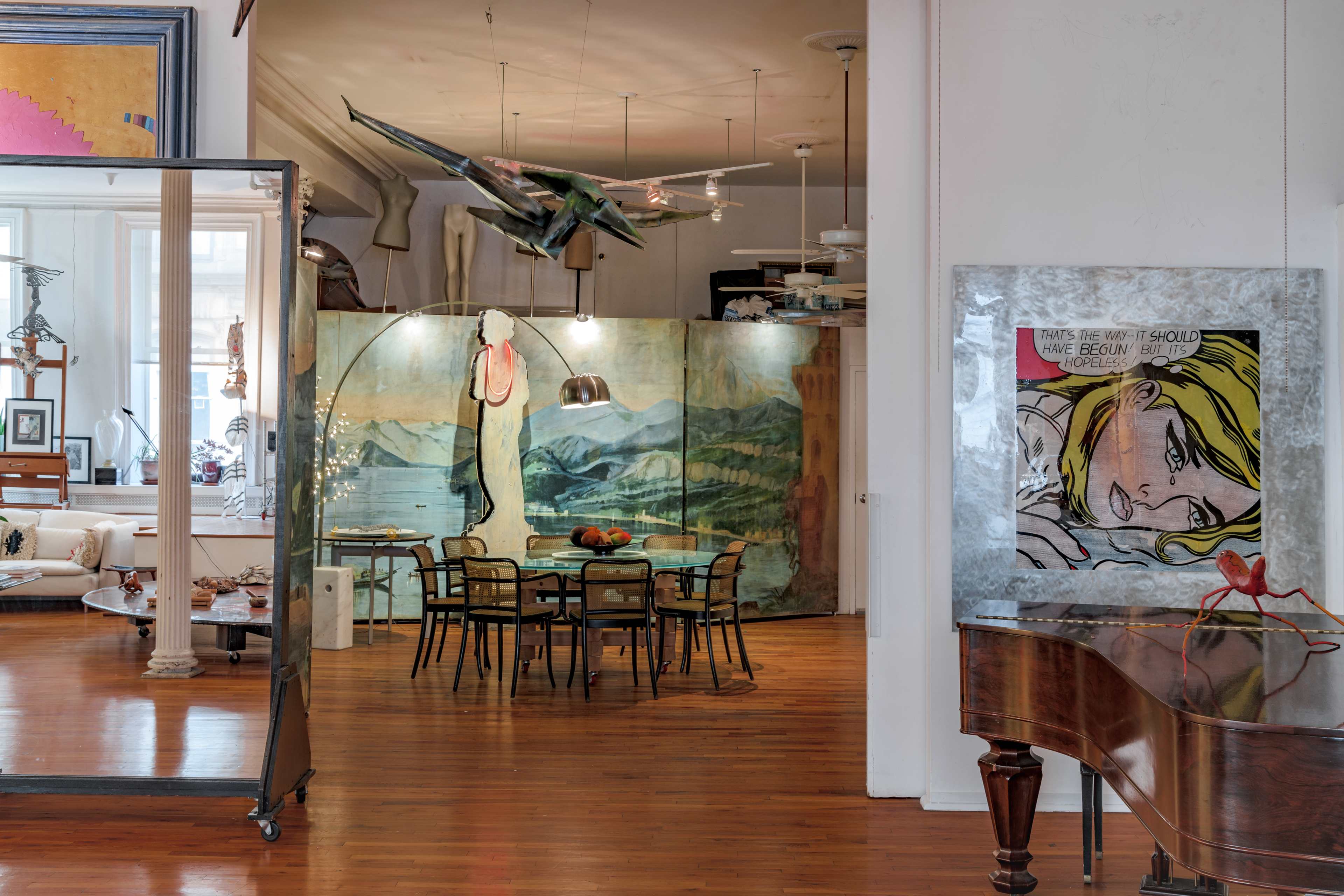 An artfully designed interior space featuring a dining area with a mural backdrop, surrounded by modern furniture and decor elements.