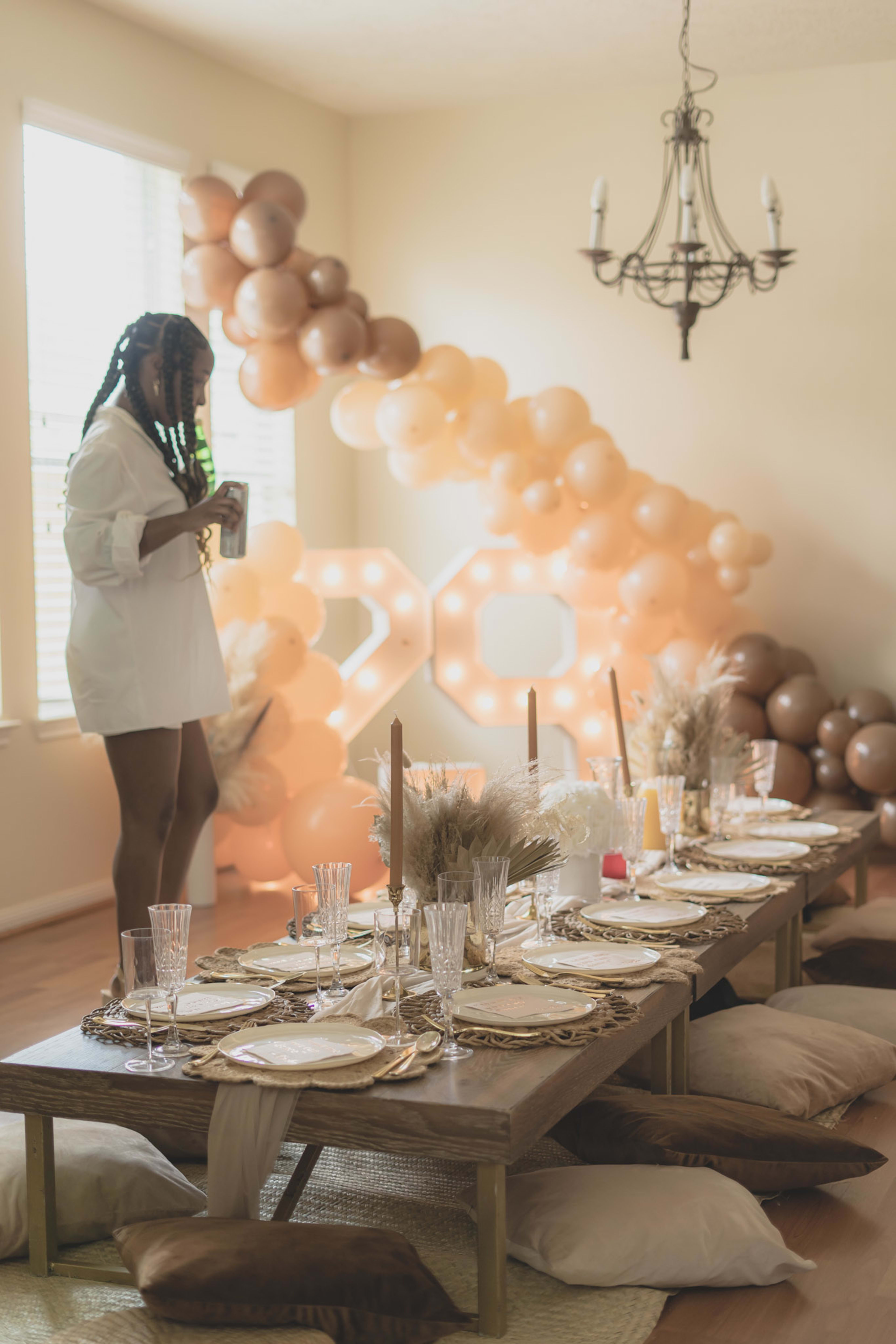 A woman standing in front of a table set for a birthday party.