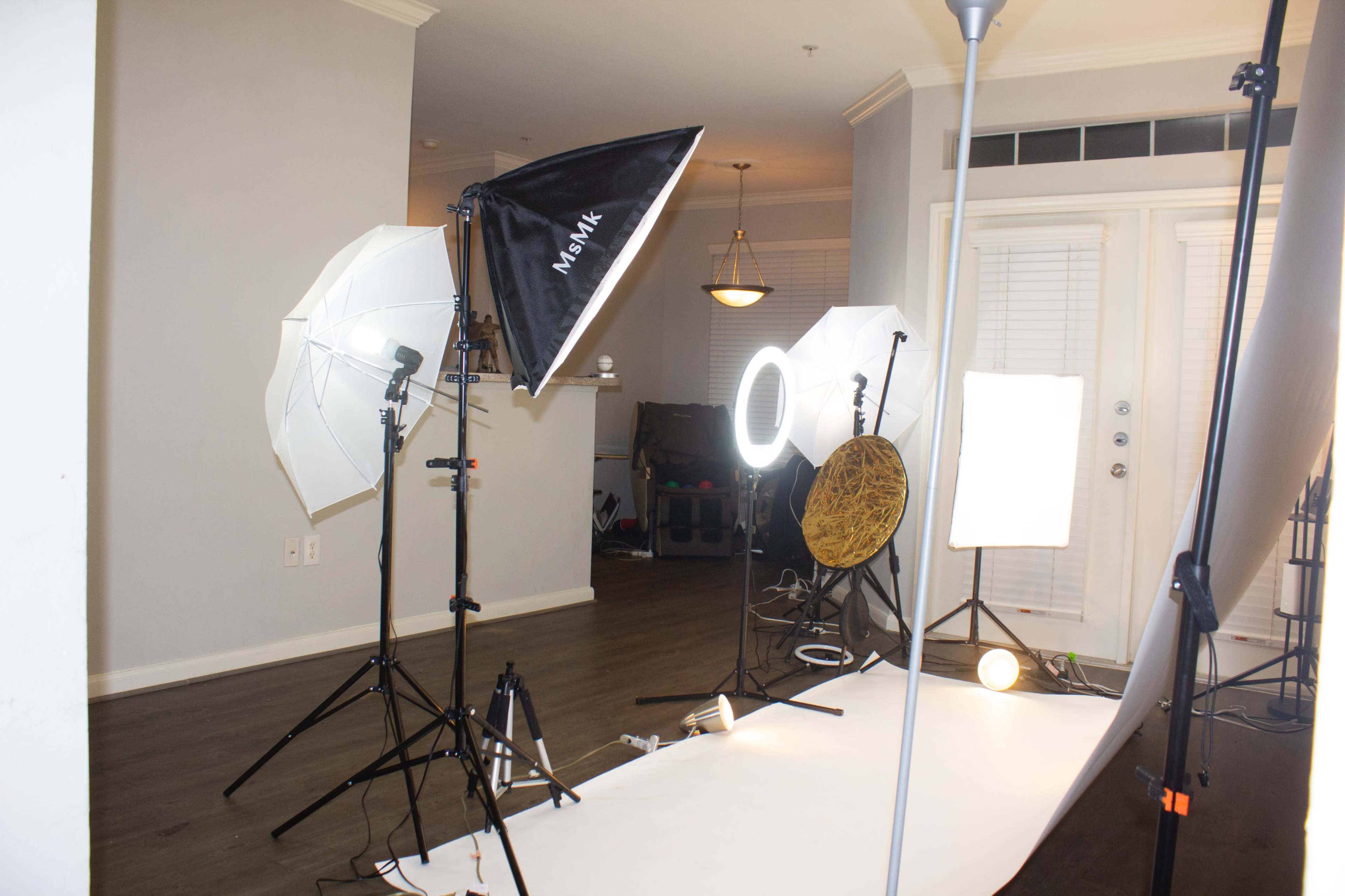 A photography studio setup with various light sources and a backdrop.