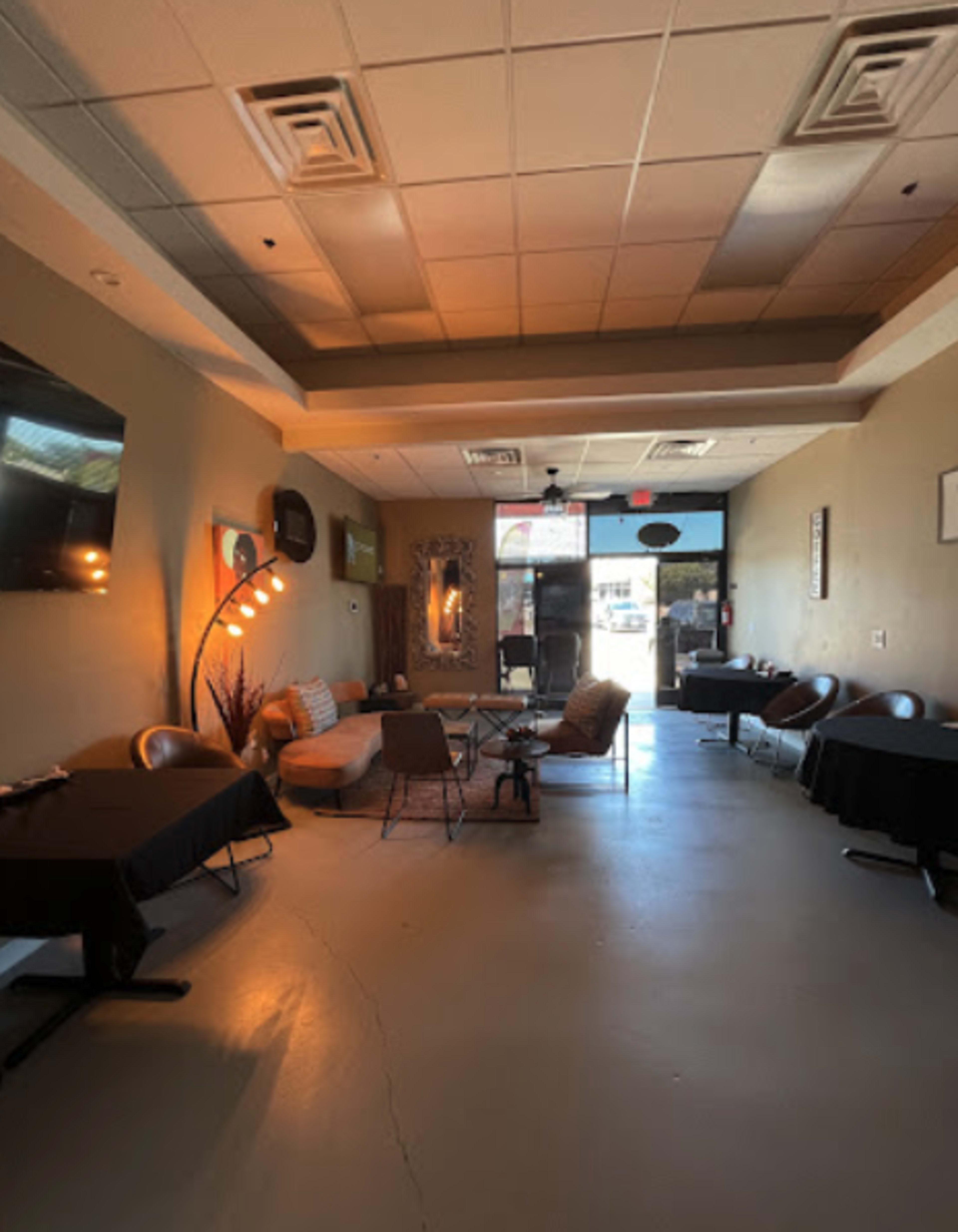A spacious, modern café interior with various seating arrangements, large windows, and decorative elements.