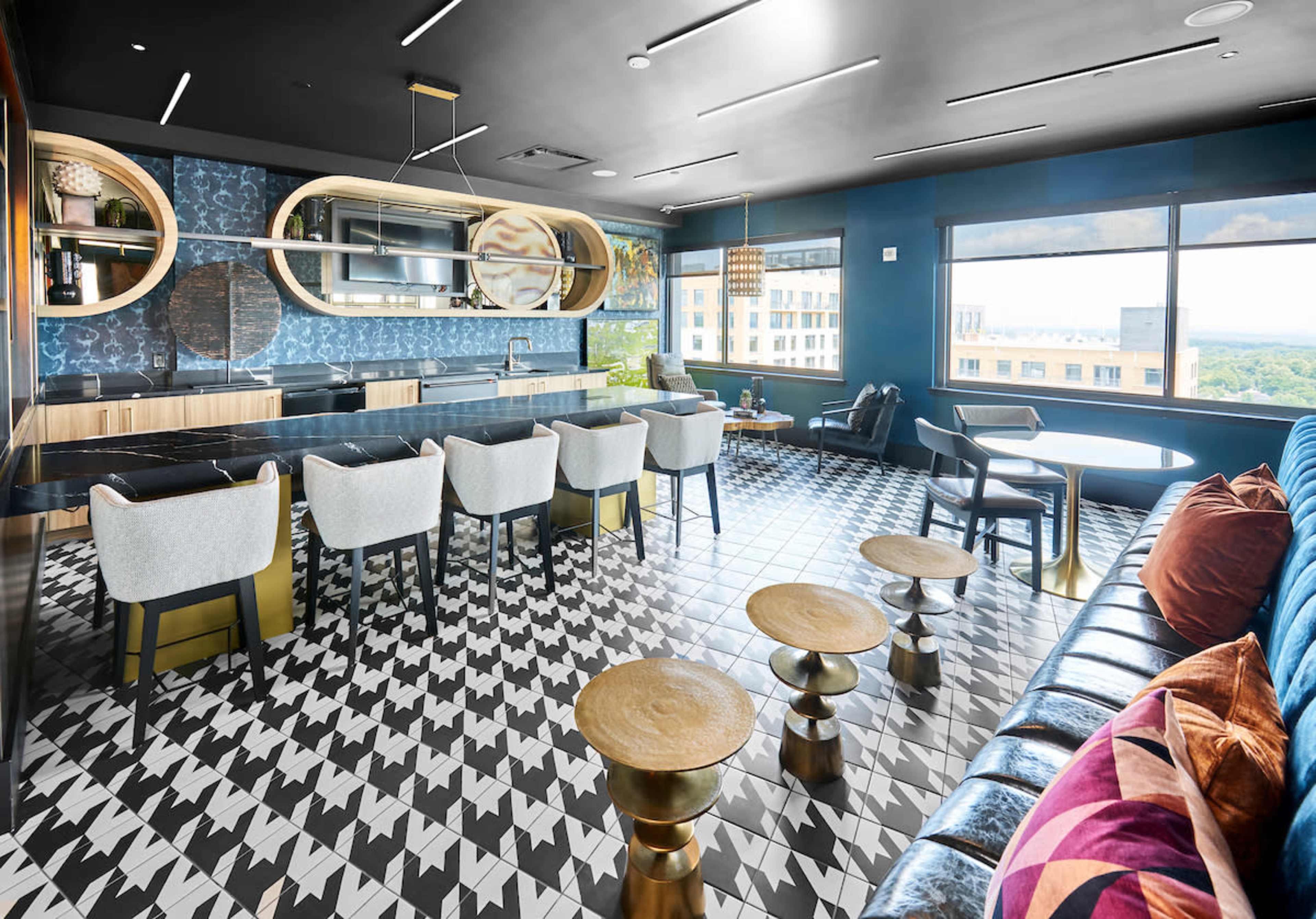 A modern lounge features a glossy houndstooth patterned floor, a long bar with seating, and large windows that overlook a cityscape.