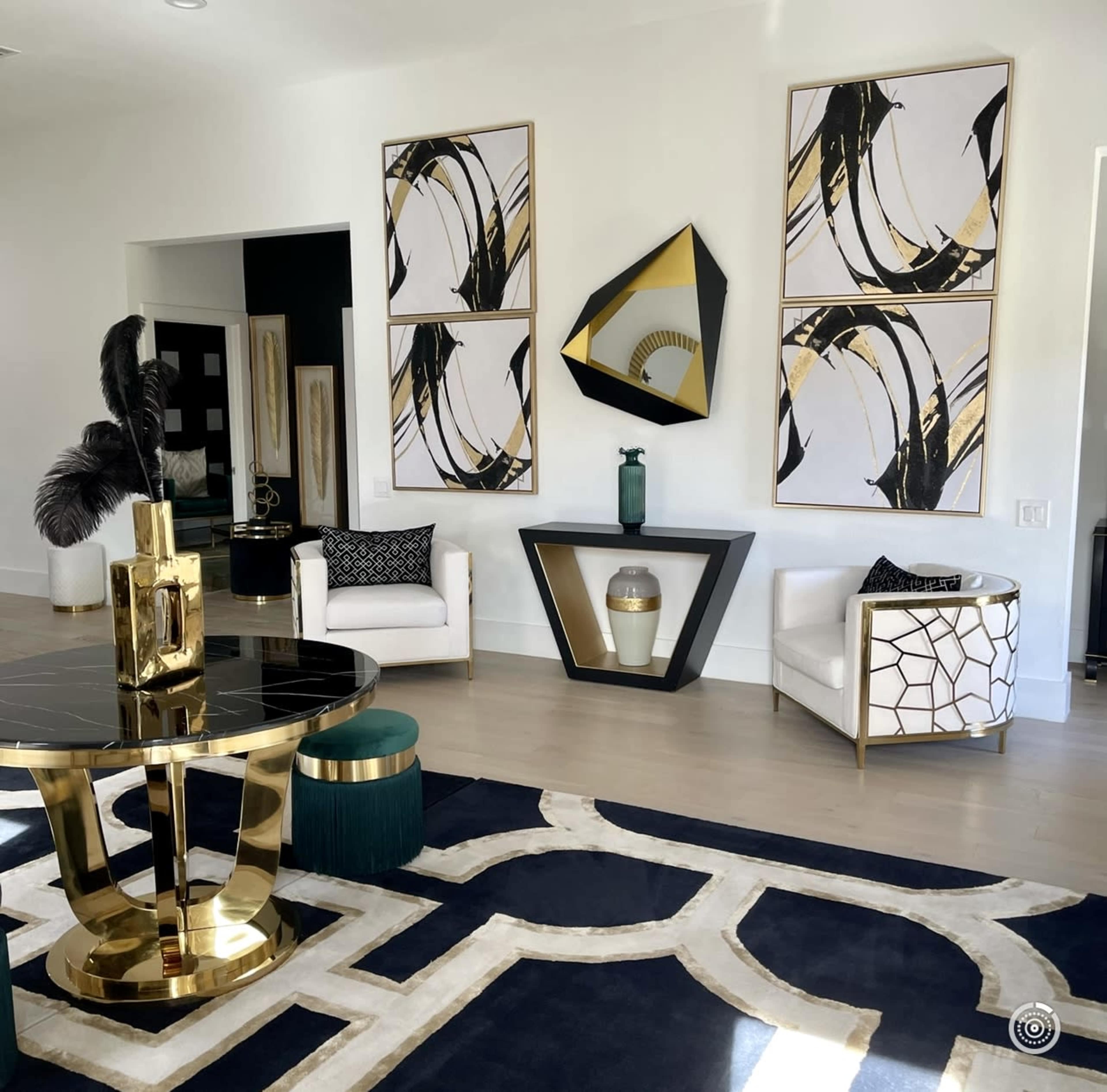 A modern living space featuring a black and gold color scheme with abstract wall art, a stylish coffee table, and minimalist seating arrangements.