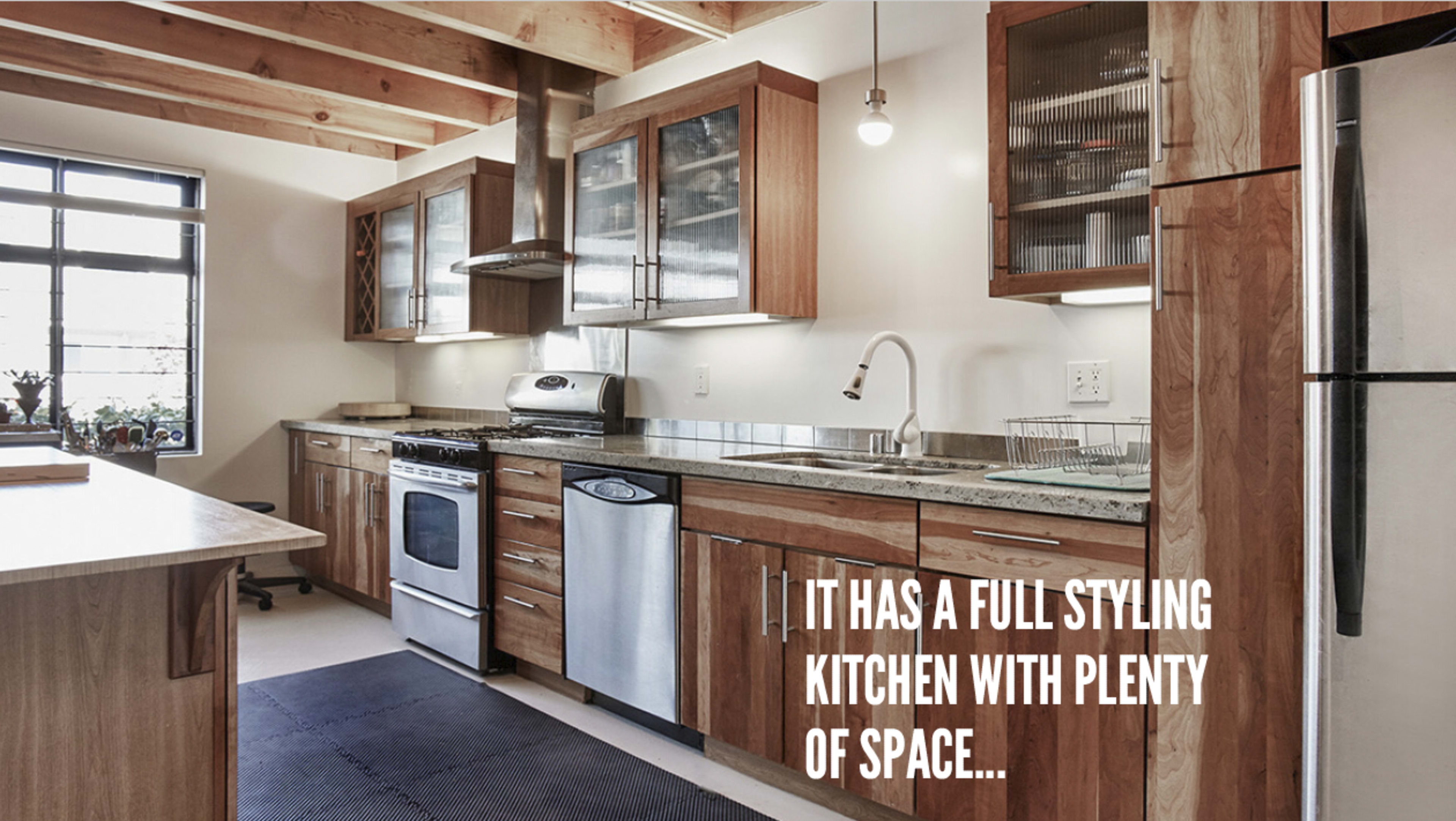 A modern kitchen featuring wooden cabinetry, a stainless steel oven, and a spacious countertop area.