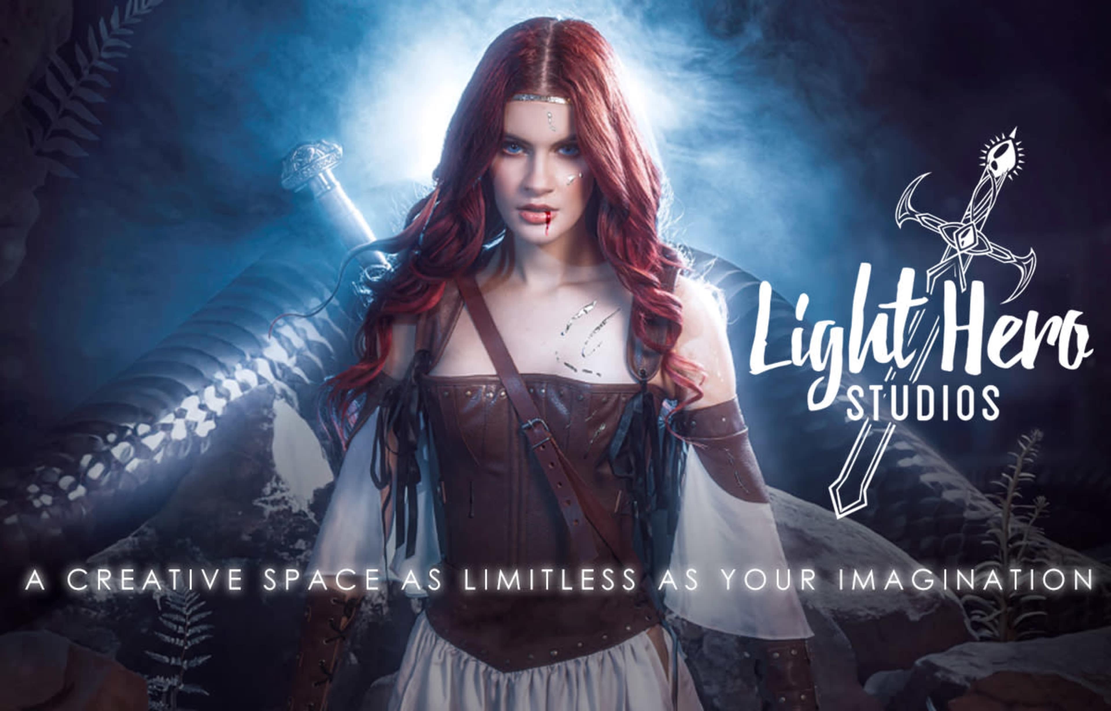 A woman with long red hair, dressed in a medieval-inspired costume, stands against a dark background, with a sword and mystical elements visible behind her.