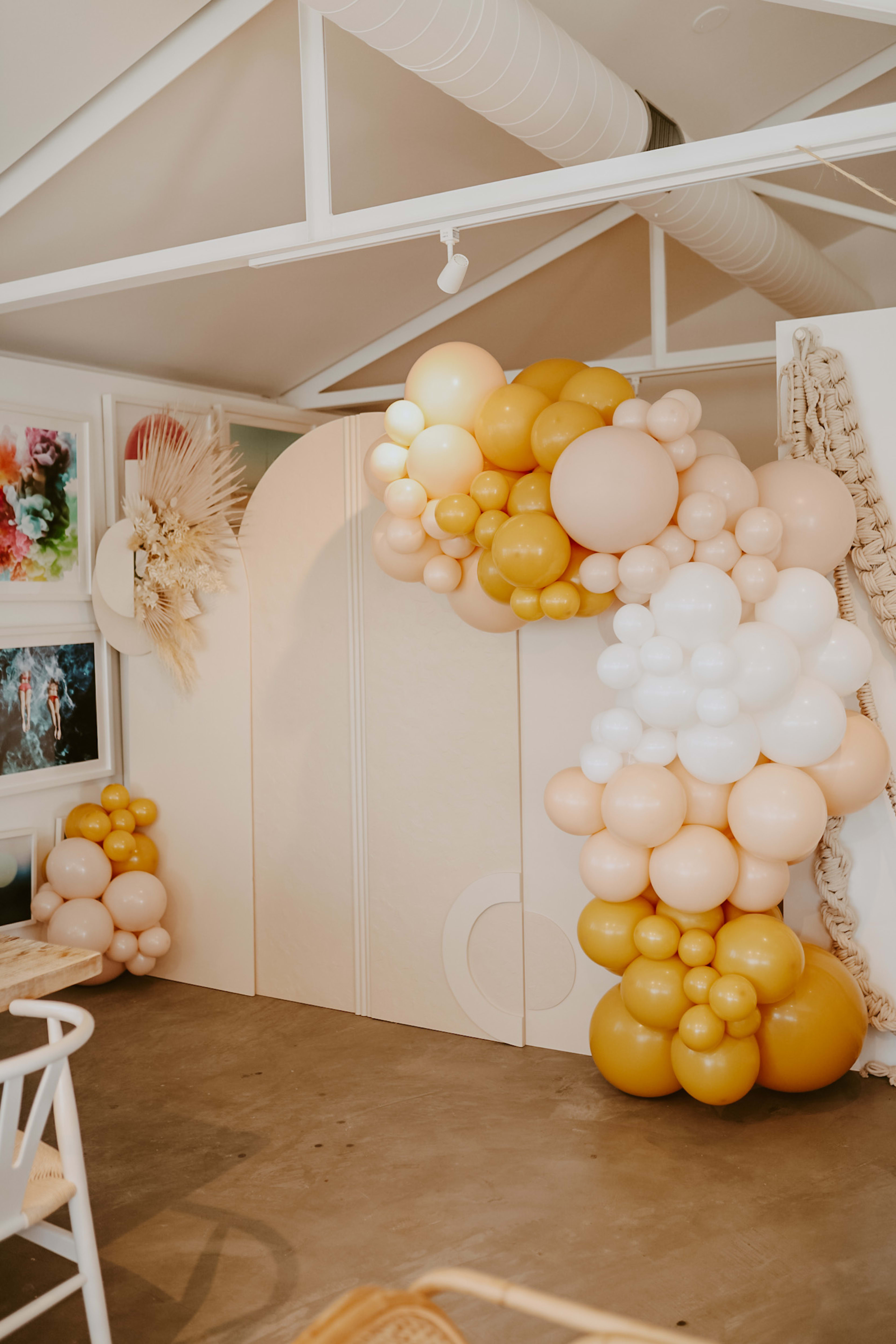 A gender neutral bunch of beige and white and yellow balloons.