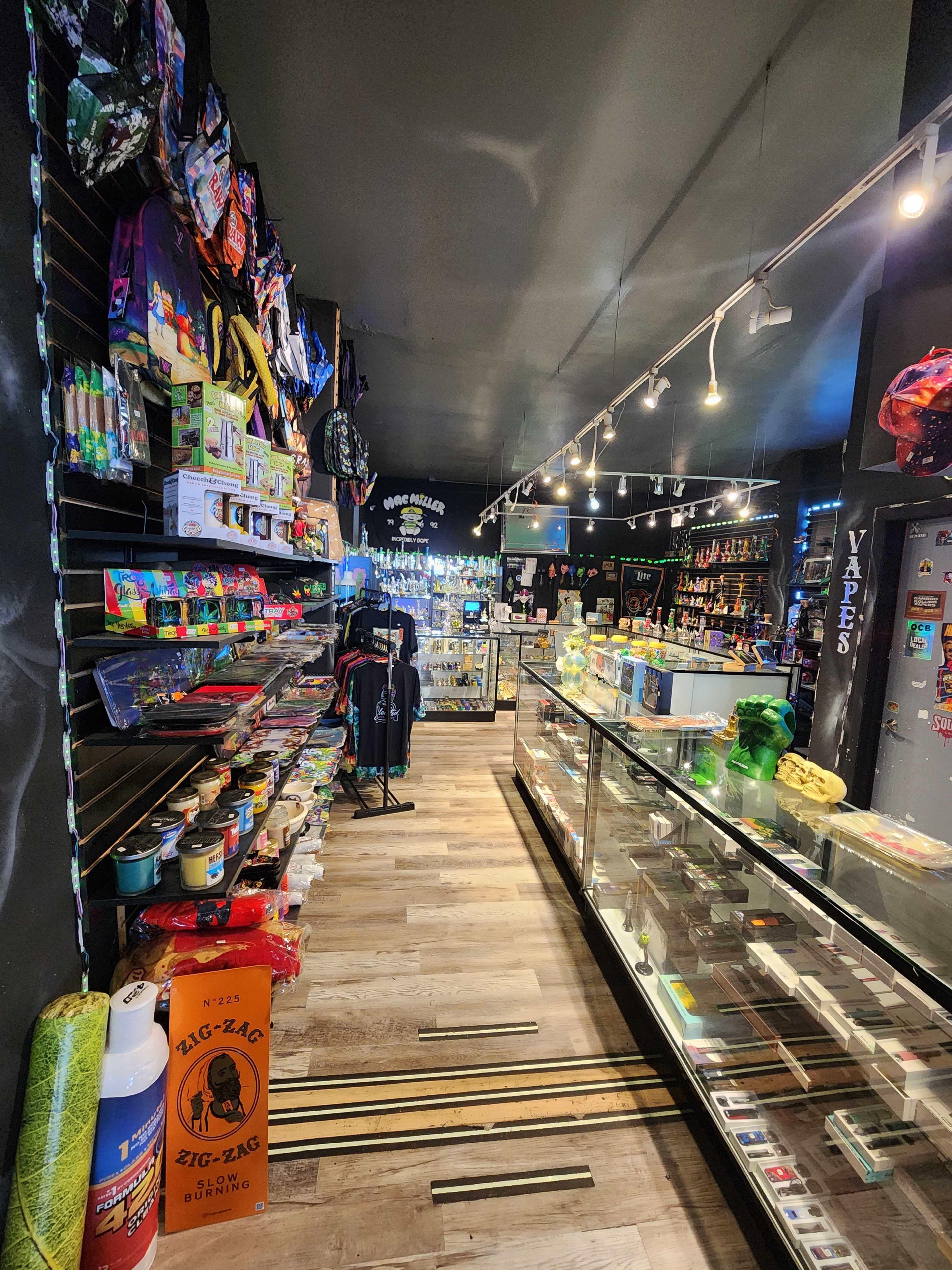 The image shows the interior of a retail store featuring shelves lined with various colorful products, display cases, and a well-lit atmosphere.